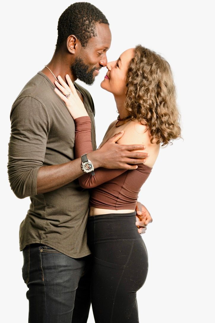 Intimate couple portrait showing tender moment against white backdrop.