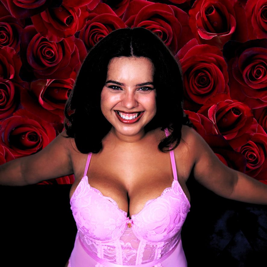 Joyful portrait against backdrop of red roses wearing pink lingerie.