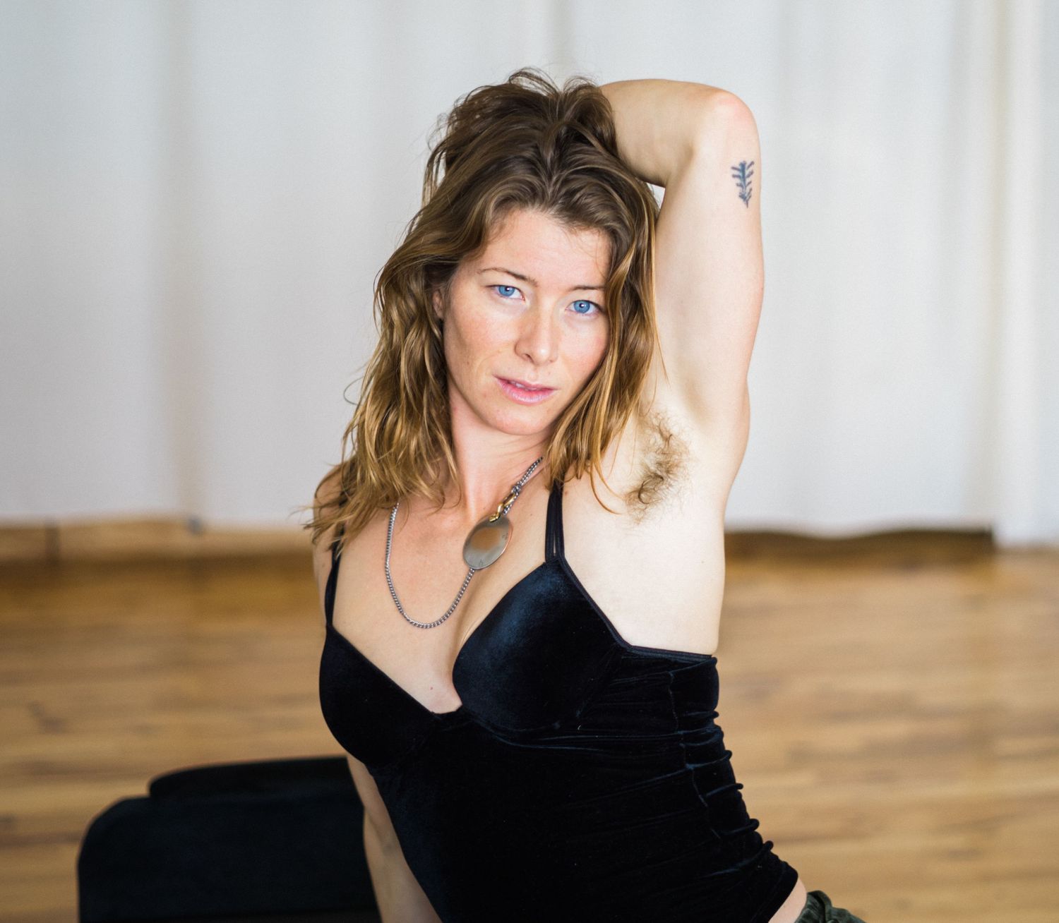 Clean minimalist portrait series in black outfit against white backdrop.