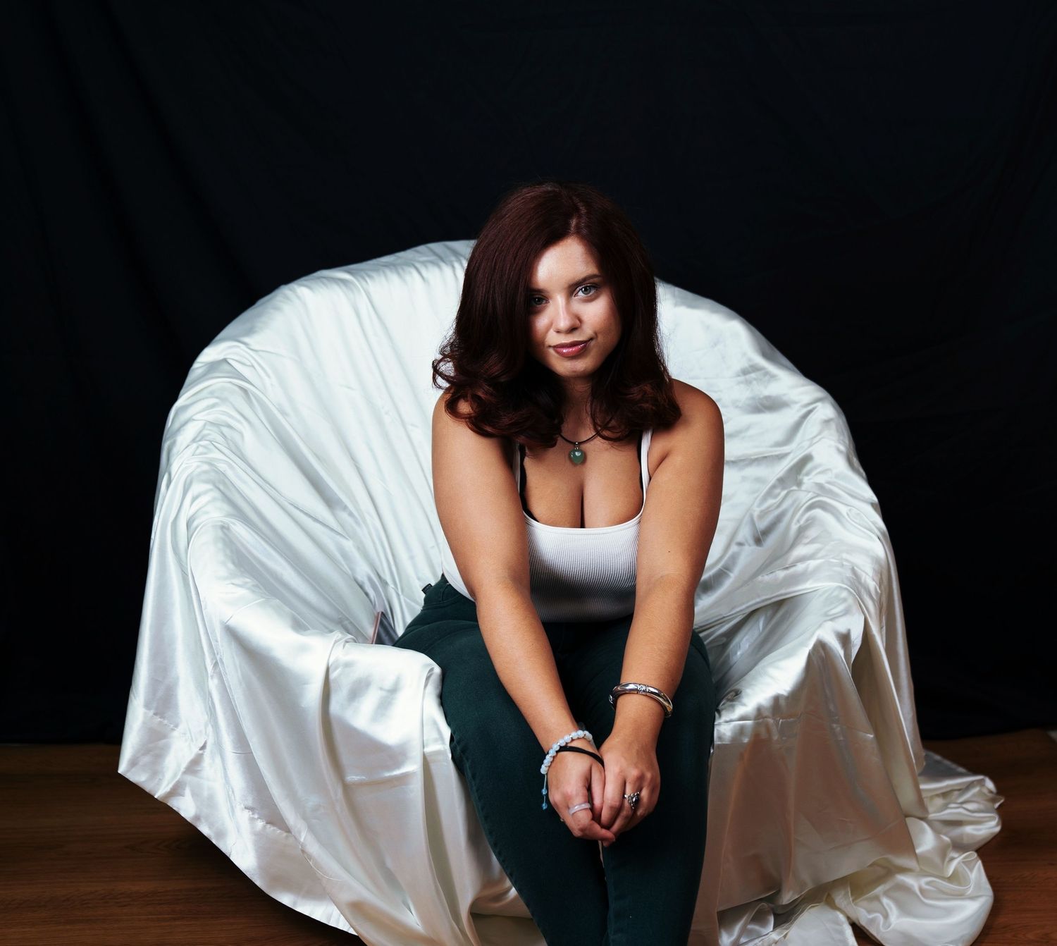 Artistic poses on white fabric backdrop in contrasting outfit.