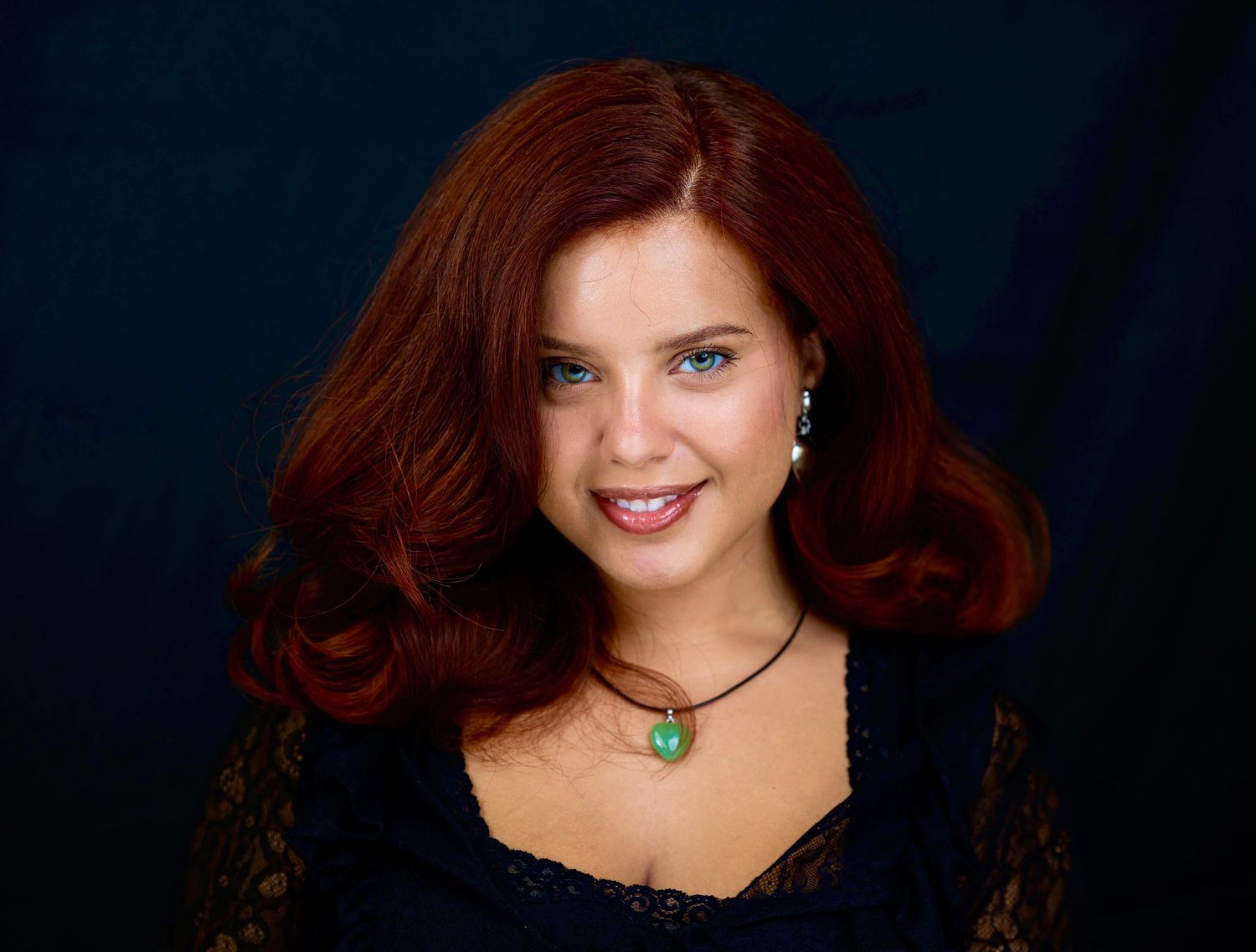 Studio portrait with dramatic lighting against dark background.