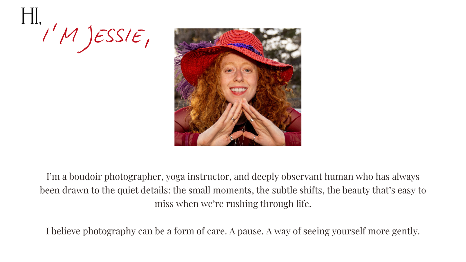 A person in a red hat with flowing red hair laughs joyfully while holding their hands near their face outdoors.