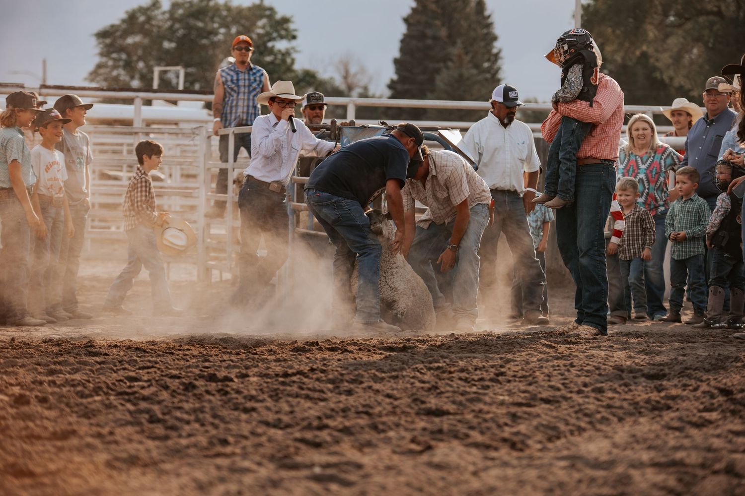 Rodeo action shot showing participants kicking up dust in an arena during mutton bustin in Kimball Nebraska