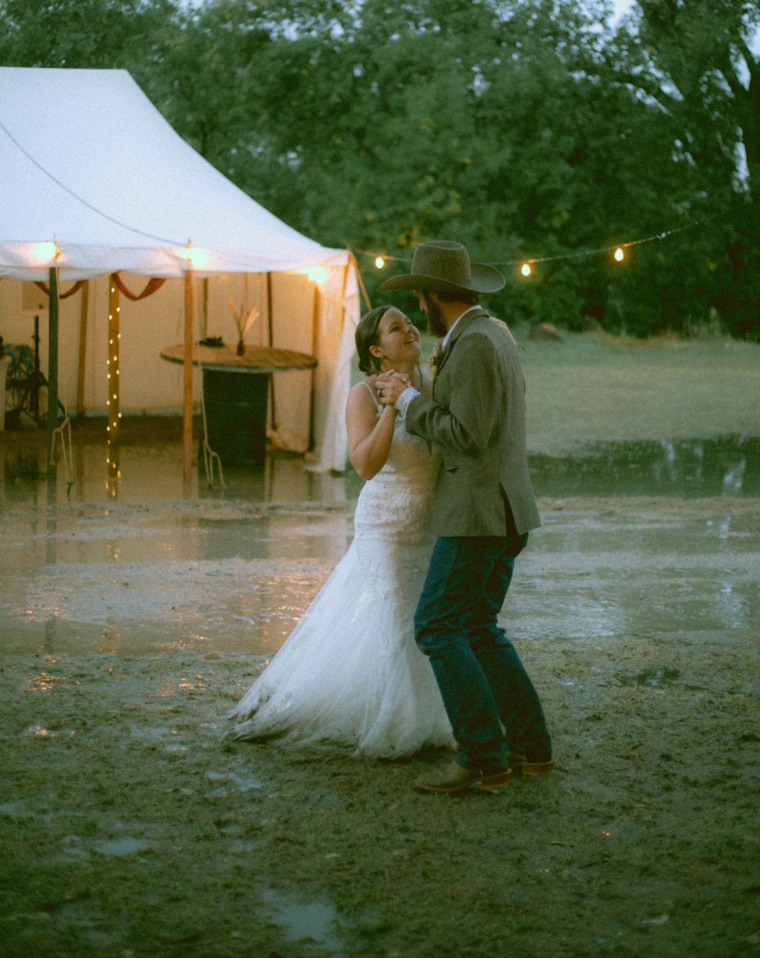 A married couple shares a romantic dance at an outdoor wedding in the rain in Western Nebraska
