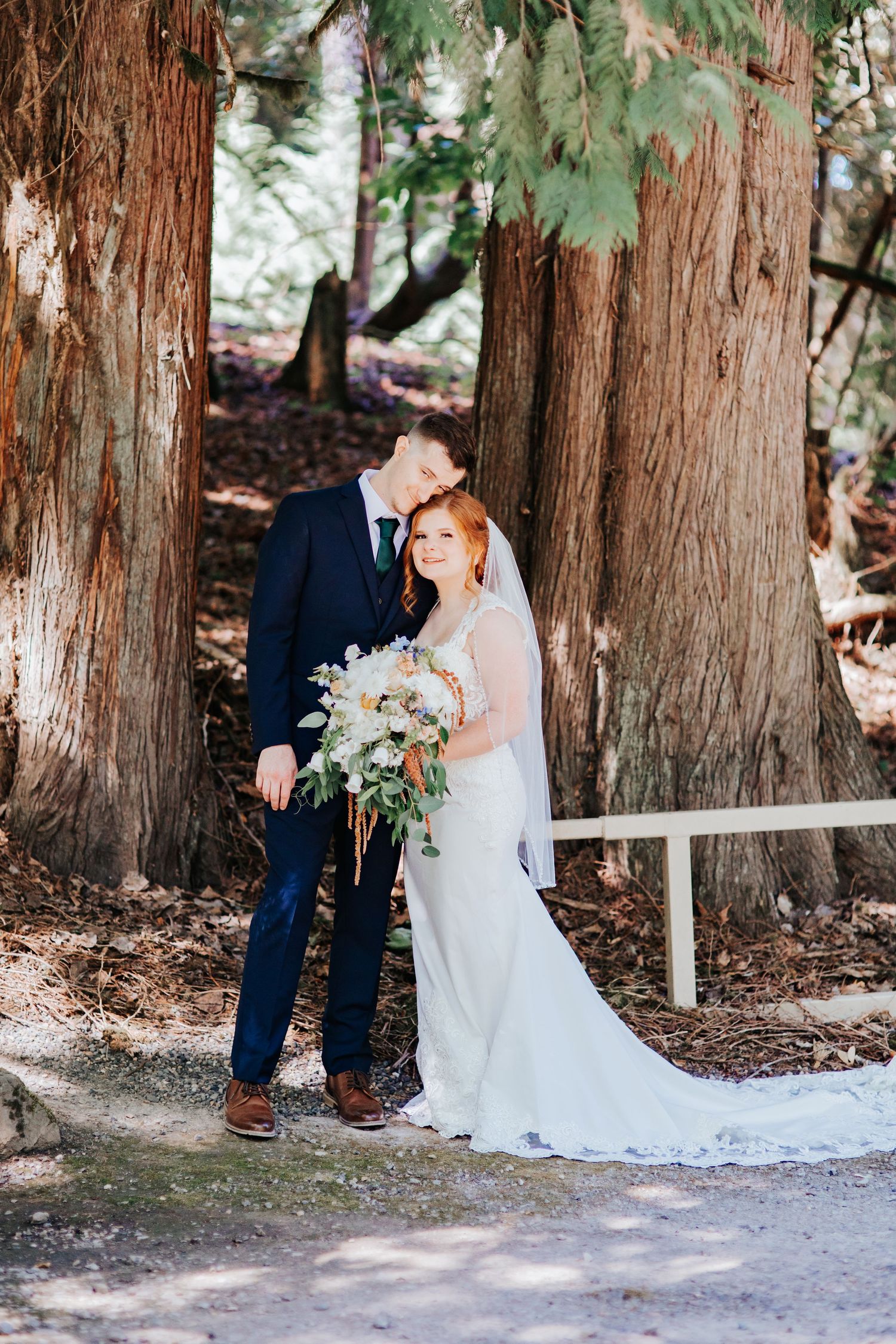 A romantic wedding couple shares intimate moments among towering cedar trees in a forest setting in La Center Oregon.