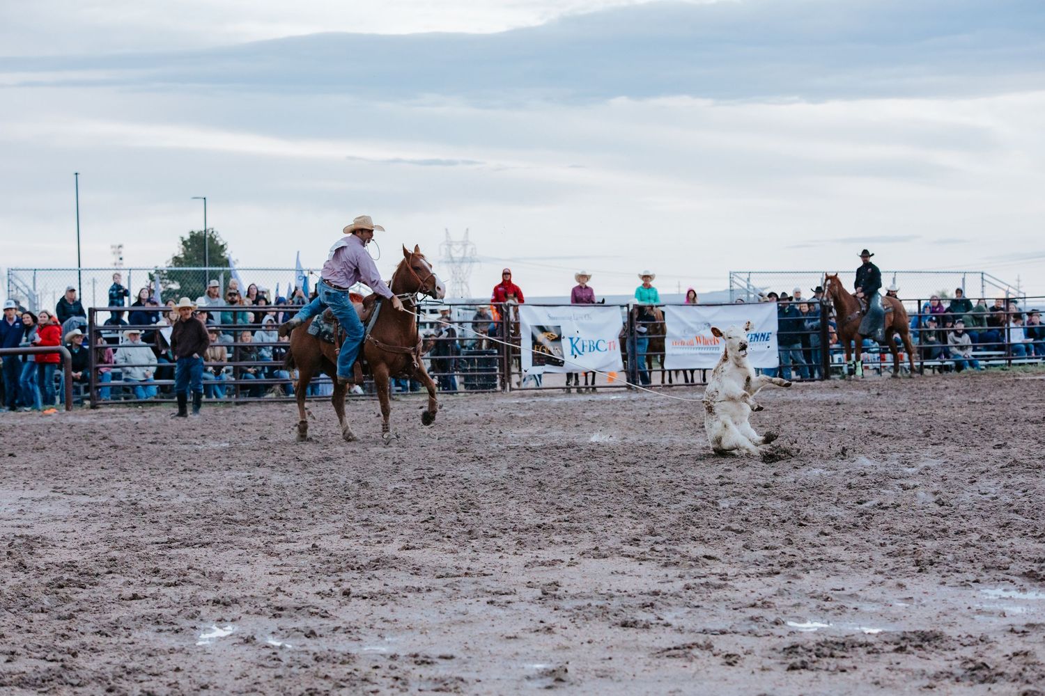 Panoramic view of a rodeo event with spectators watching from the sidelines.