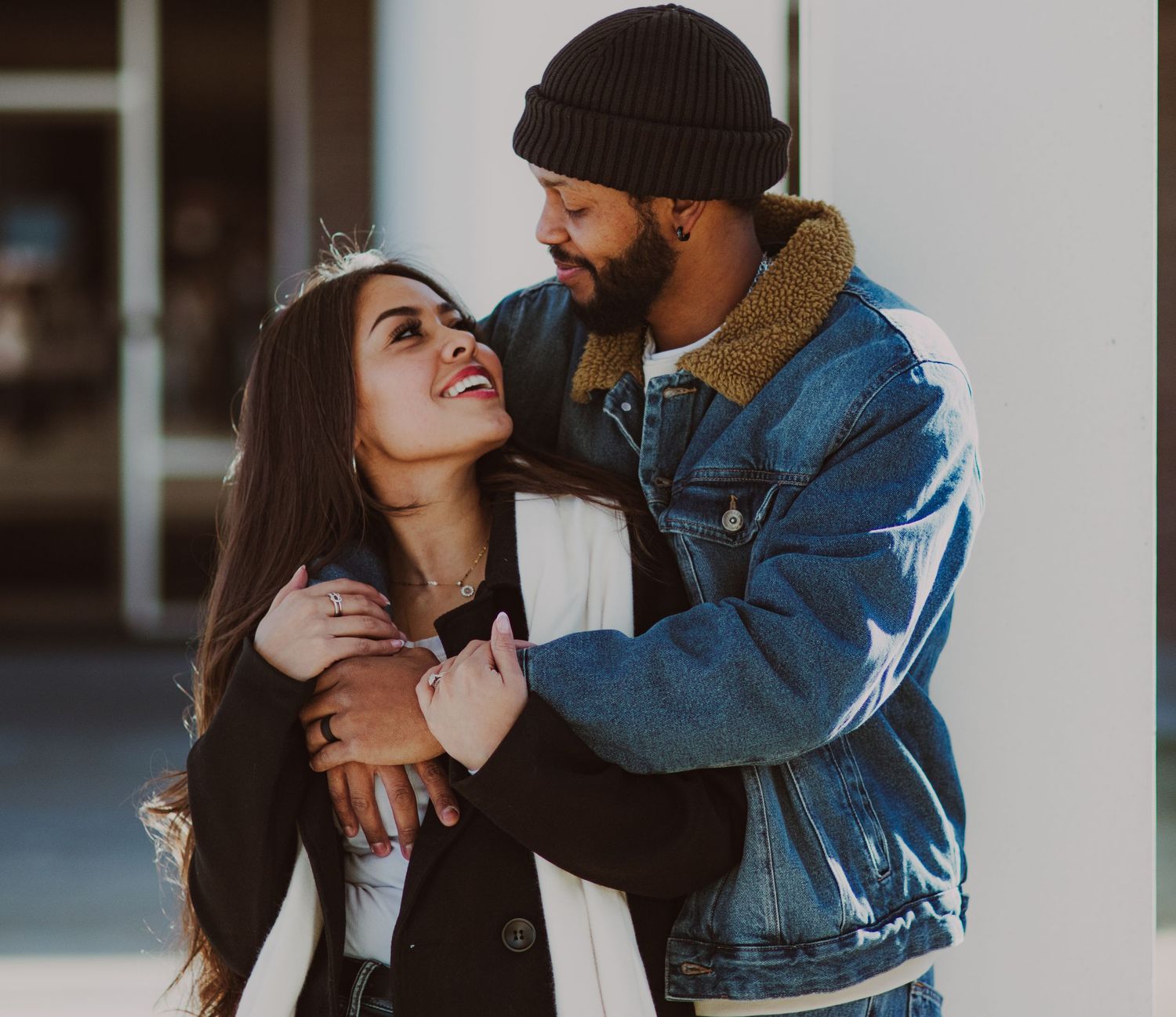 A couple in a denim jacket and beanie share intimate moments in a romantic outdoor photoshoot series.