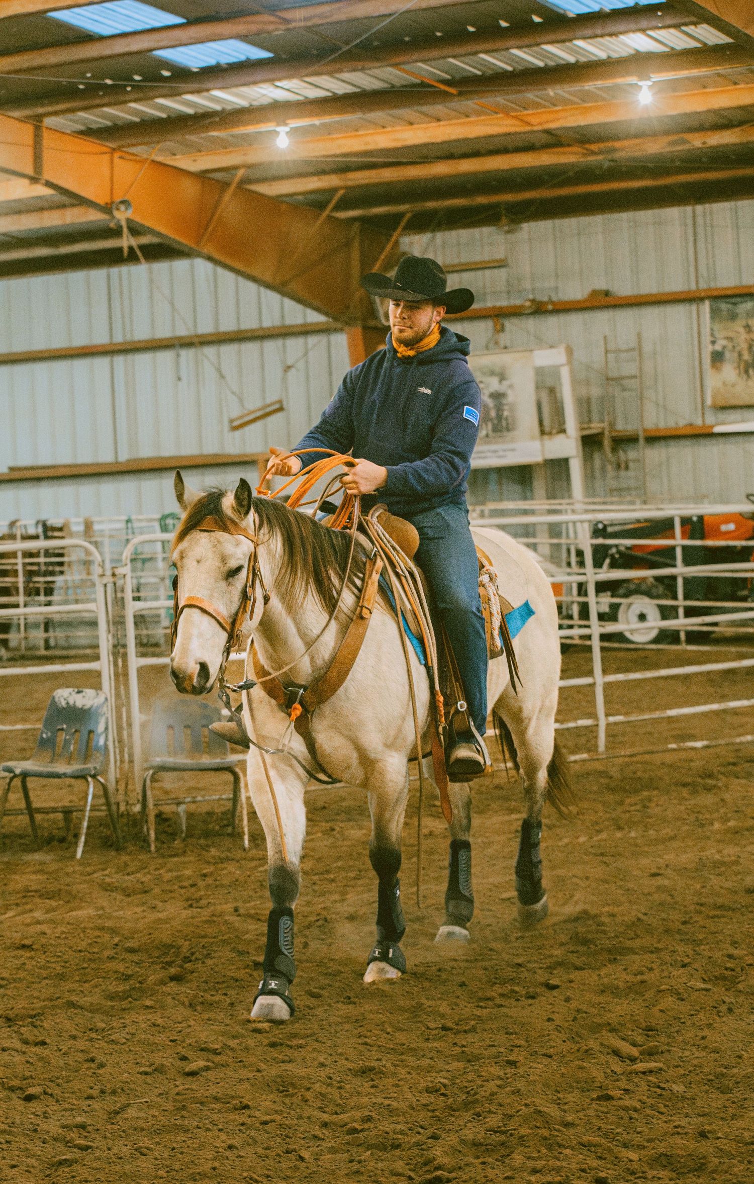 Indoor horse riding training session with riders practicing in a covered arena in Belle Fourche South Dakota.
