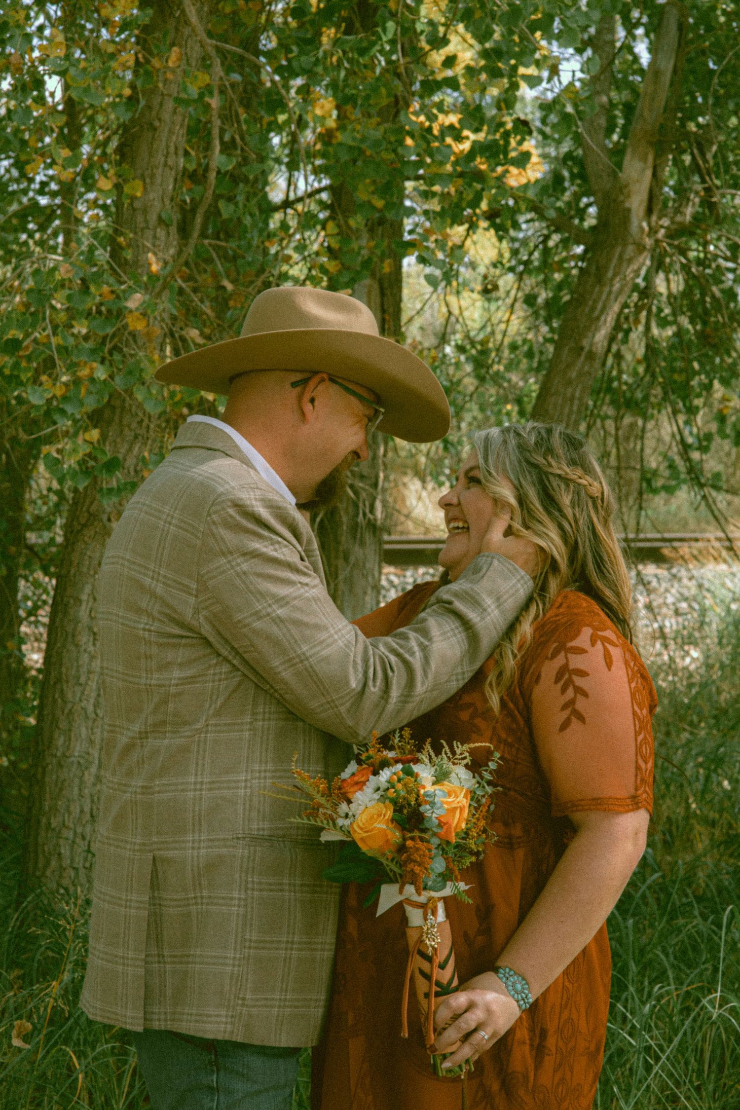 A eloped couple on a dirt road in Sterling Colorado in western attire