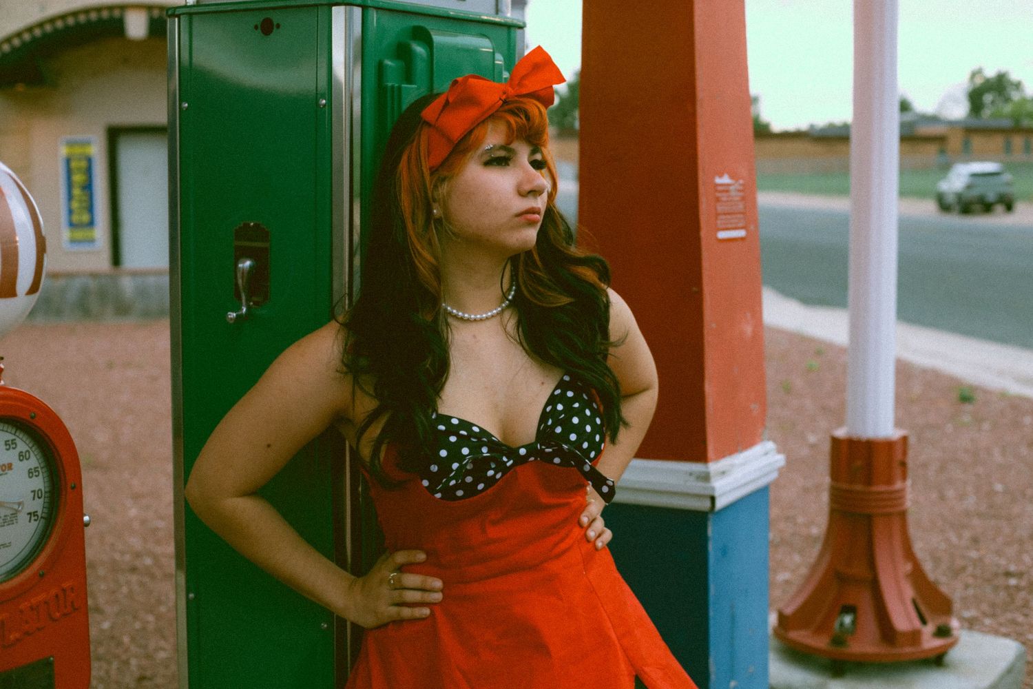 Vintage-style high school senior photographs  in polka dot retro dress near a vintage gas pump in Nebraska