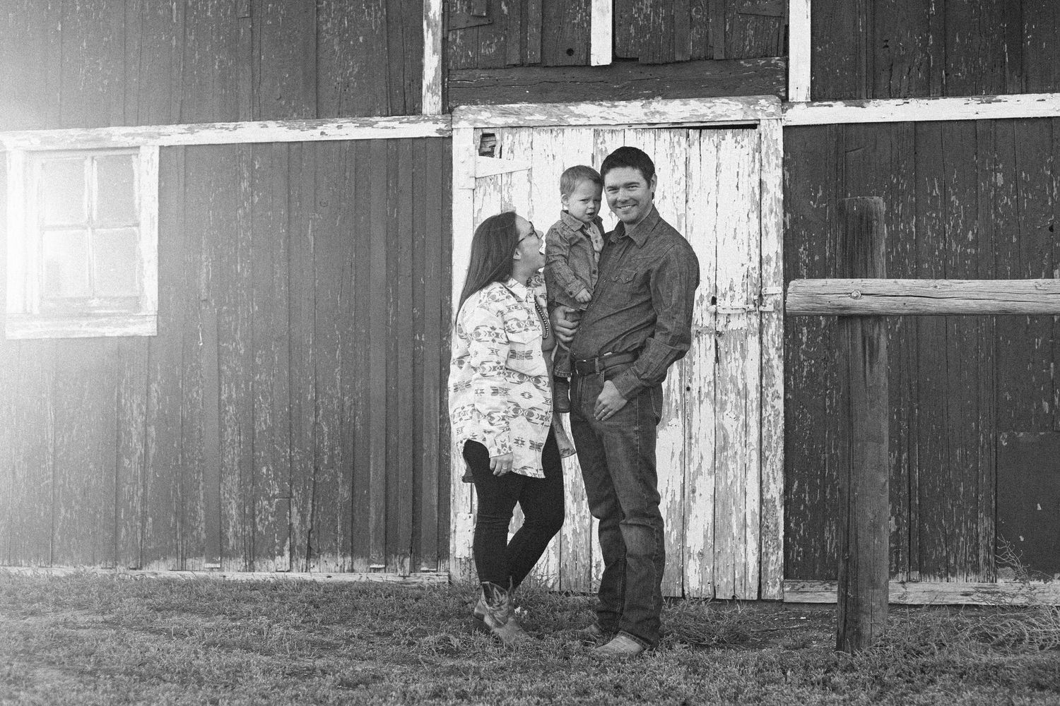 A black and white vintage photograph showing a snowy winter scene with a family barn for a western storytelling family session in western NE