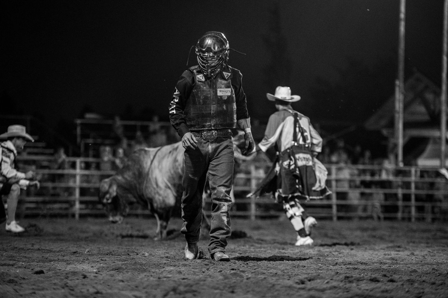Rodeo action sequence showing a cowboy competing in a bull riding event at a dusty arena in Kimball Nebraska.