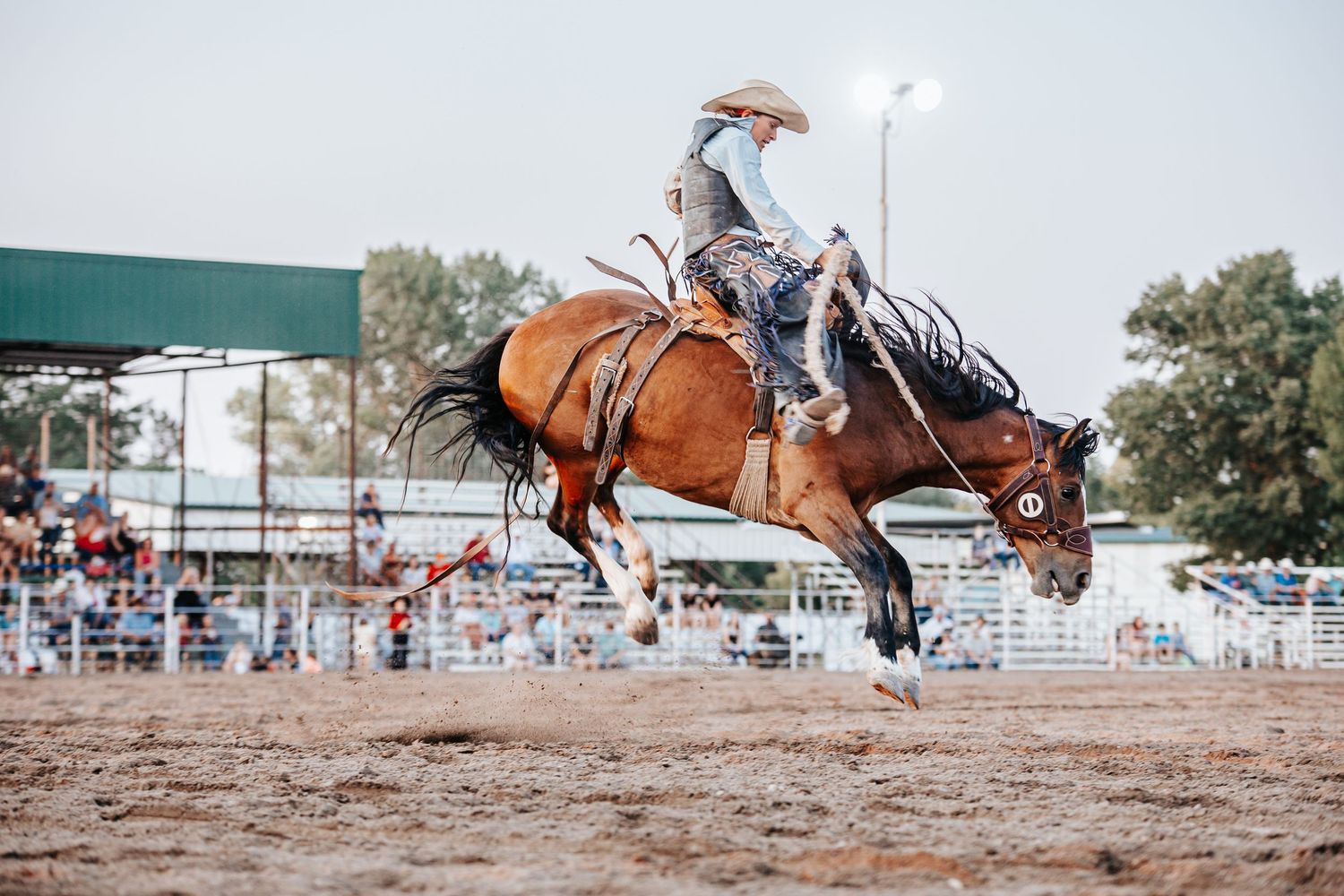 Rodeo riders competing in various events across a dusty outdoor arena.