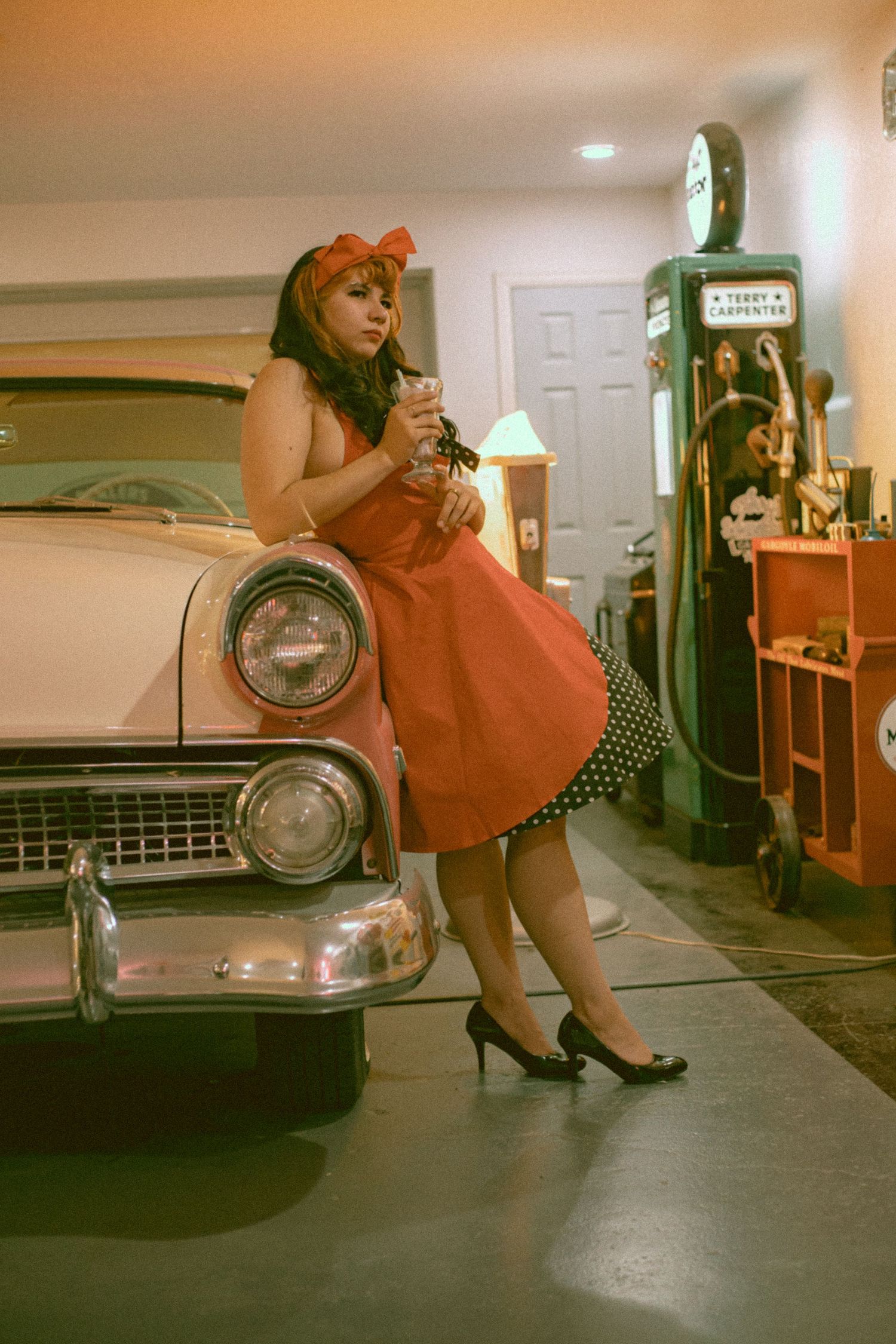 Vintage 1950s scene with red dress and classic car near for a high school senior in Nebraska