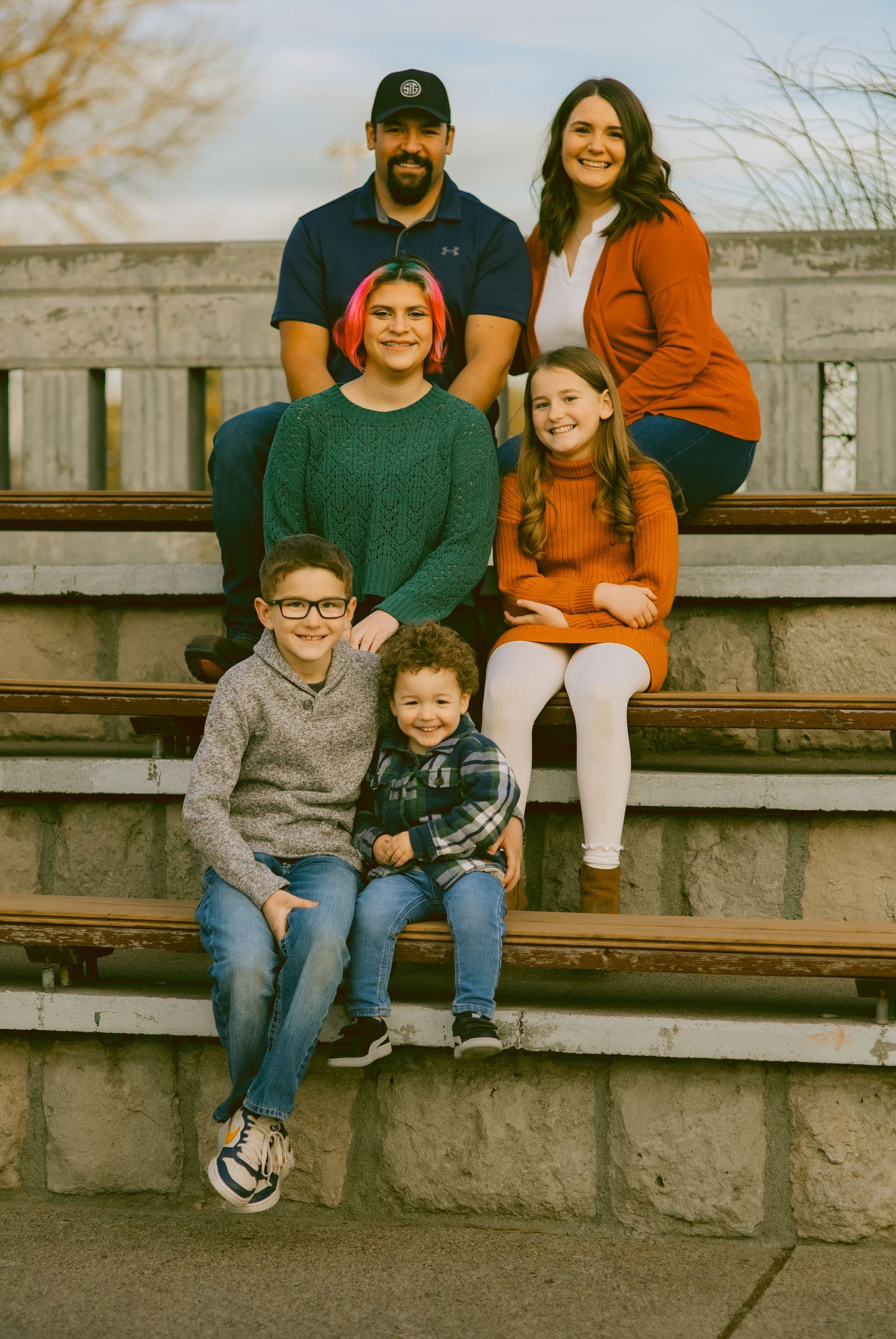 Family sits together on concrete bleachers during a casual outdoor gathering in Sidney Nebraska.