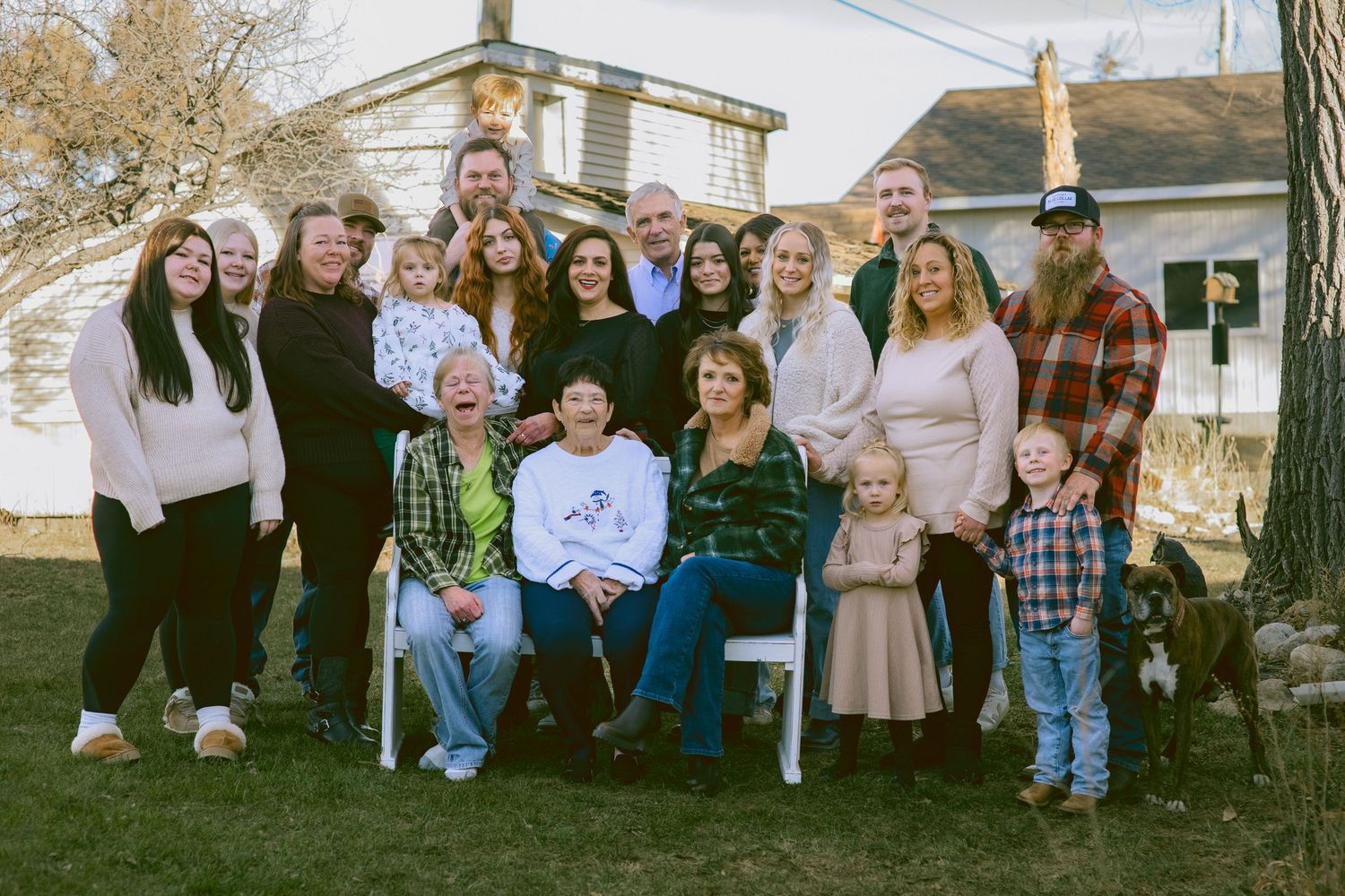 A Multi generational family session sitting and standing outdoors in western Nebraska