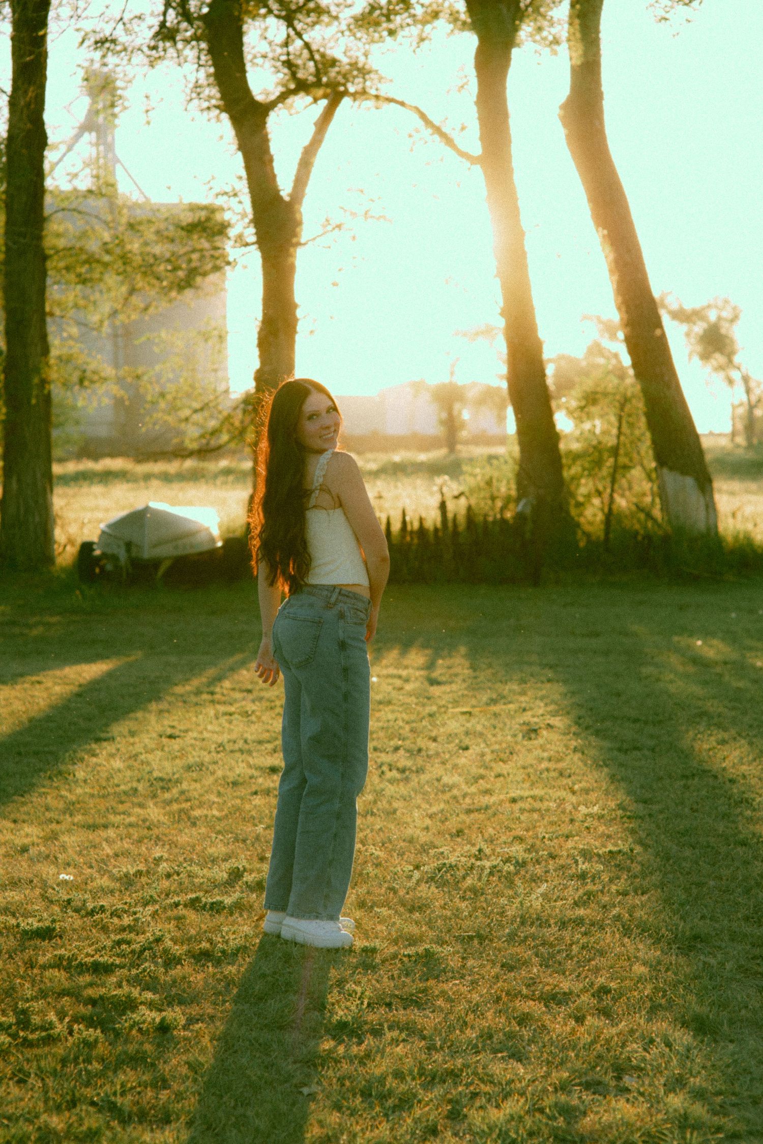 Silhouette of trees at sunset creating long shadows on grassy ground from a senior session.
