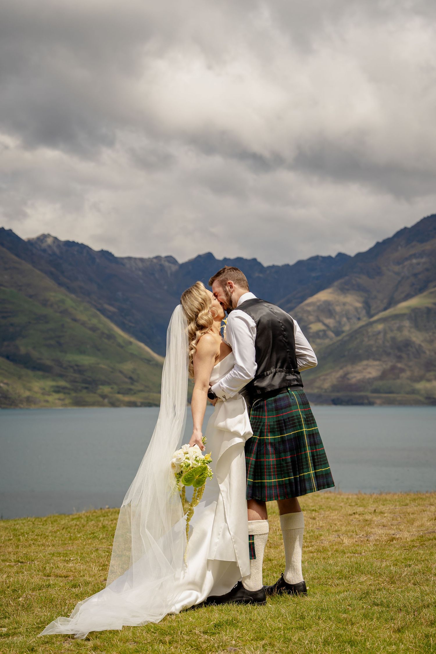 Bride and Groom portrait in mountains with Lake Wakatipu, Queenstown New Zealand.