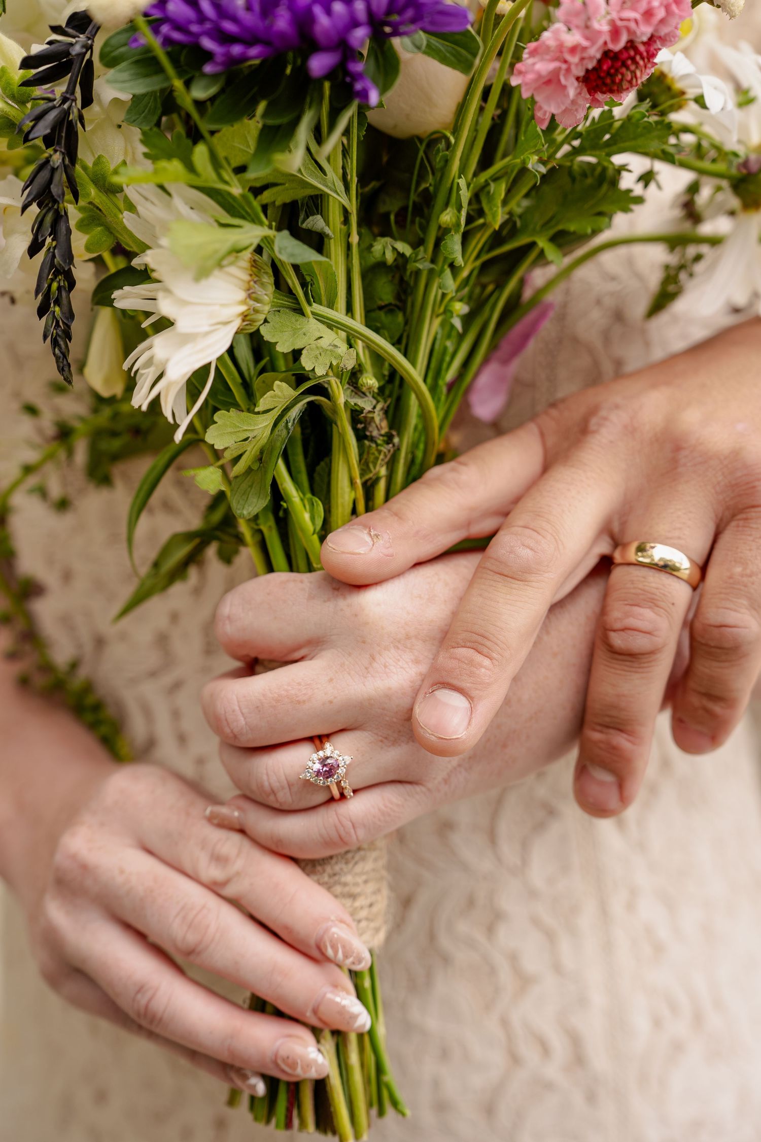 Bride and groom holding a bouquet, showing their rings in Queentown elopement.