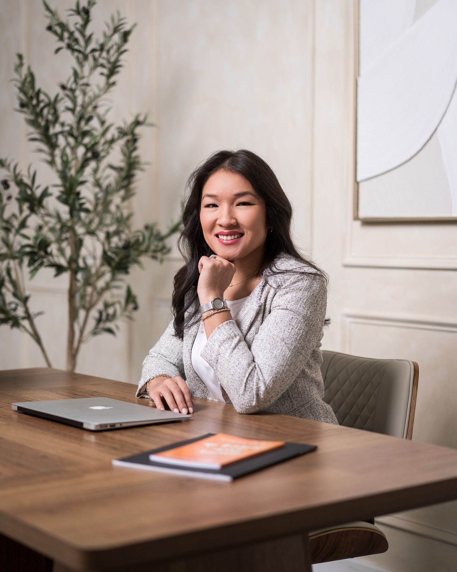 Professional woman working with tablet at wooden desk in bright office space.