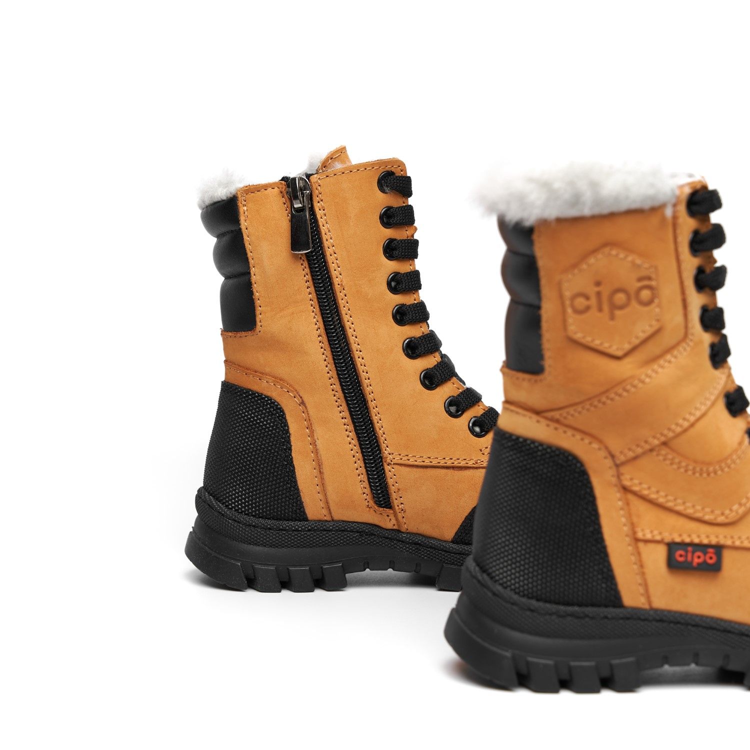 Tan and black winter boots with fur lining and side zipper closure shown from the side.