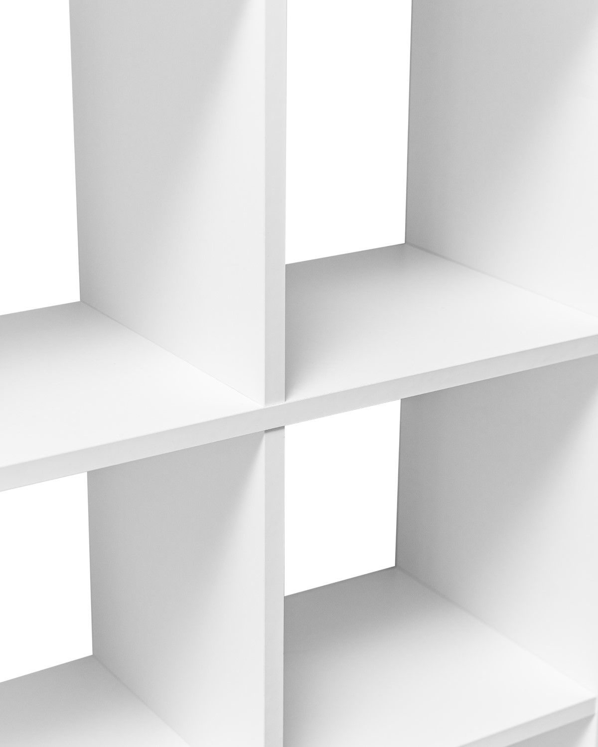 Close-up view of white cubic shelving system showing geometric compartments and shadows.