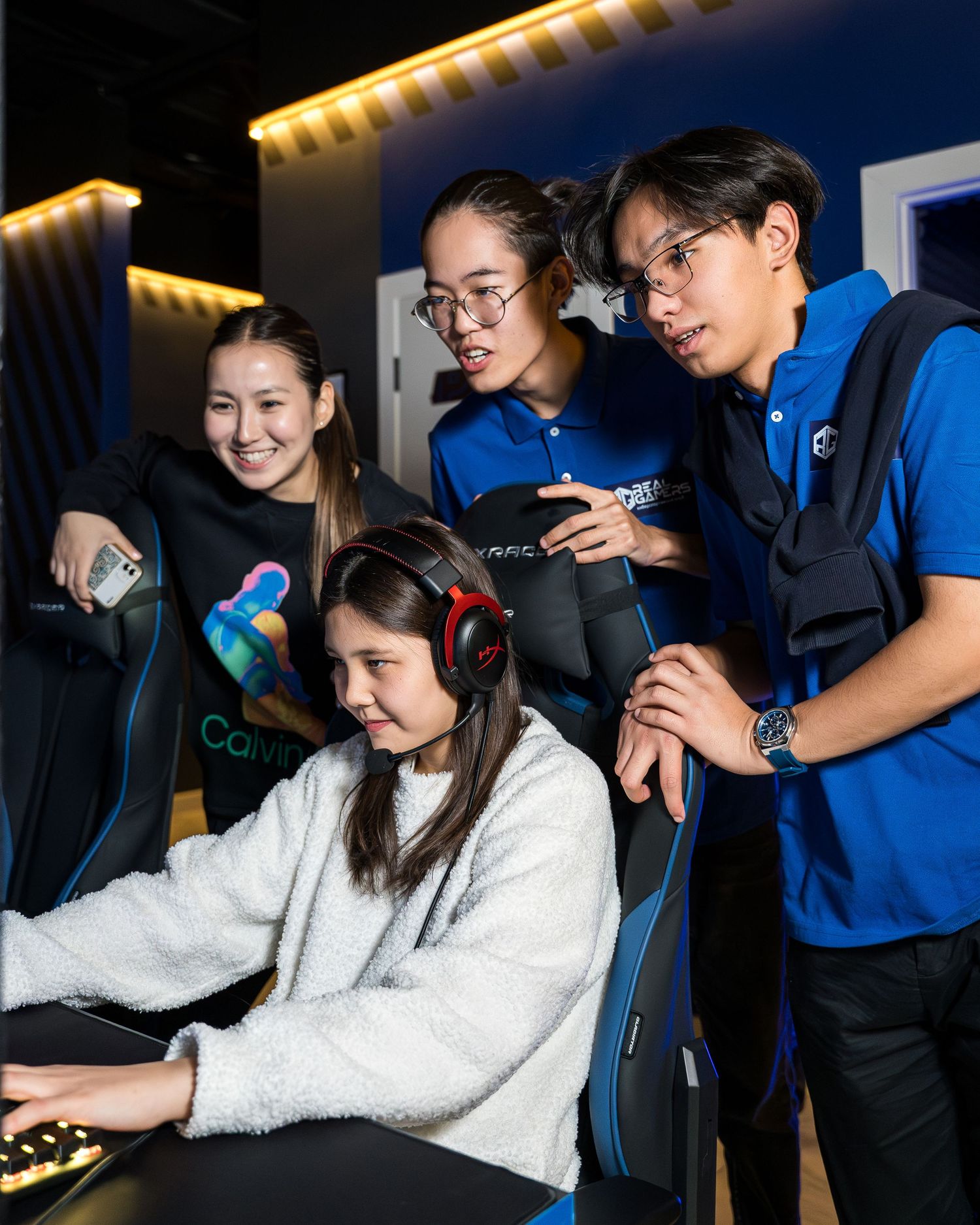 Group of friends playing video games together with intense focus and excitement in a dark room.
