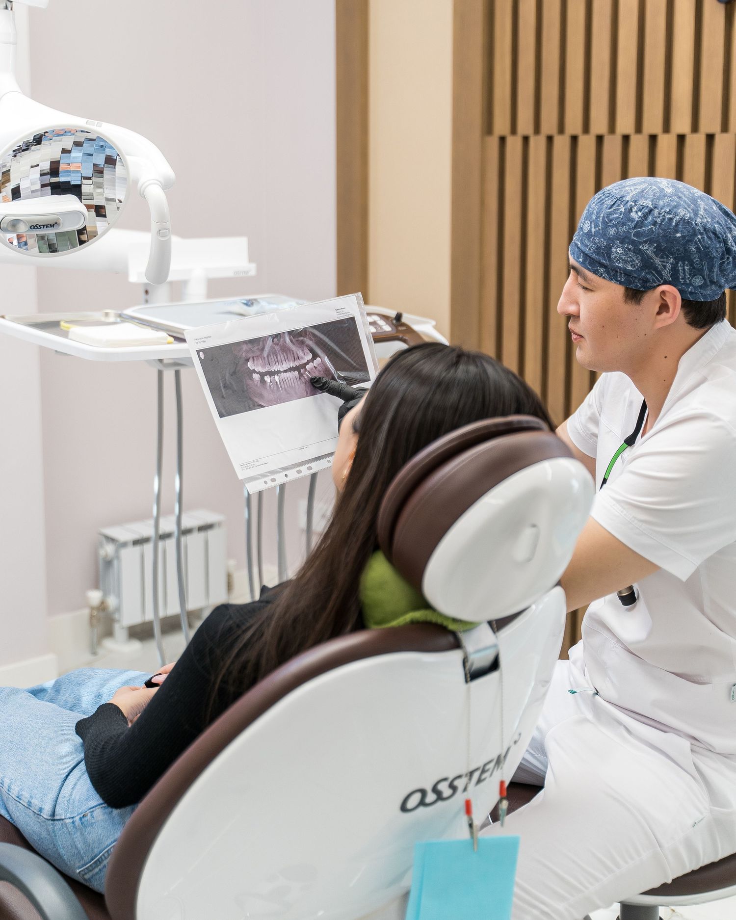 Patient receiving dental treatment in modern dental office with specialized equipment.