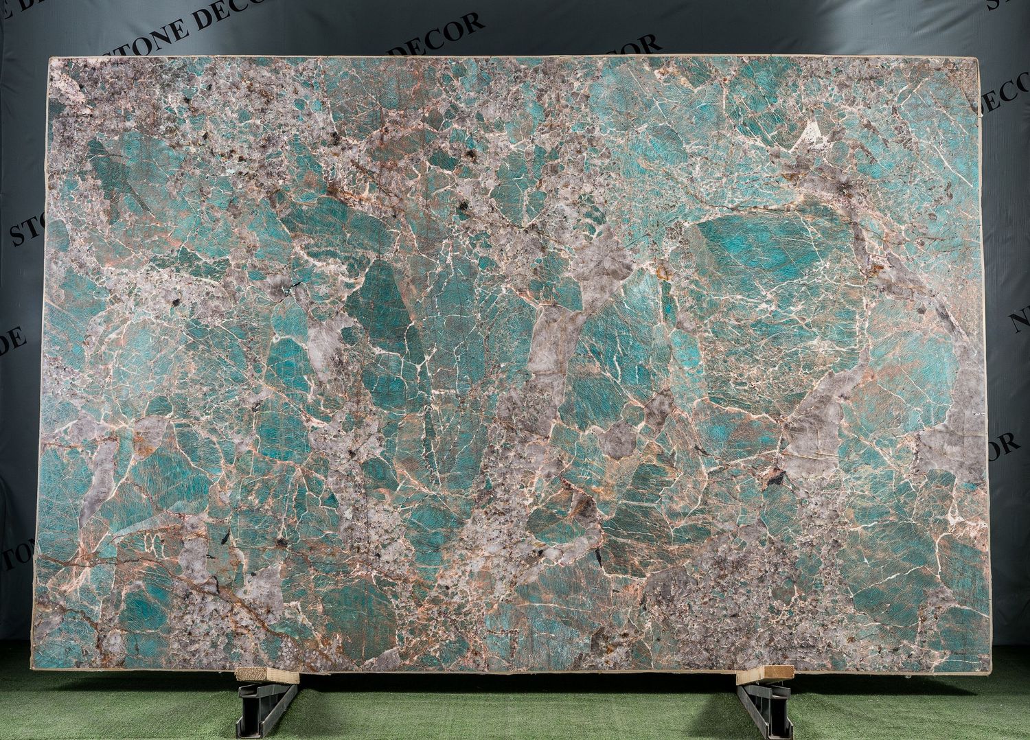 Large decorative stone panels featuring turquoise and copper tones mounted on display stands.