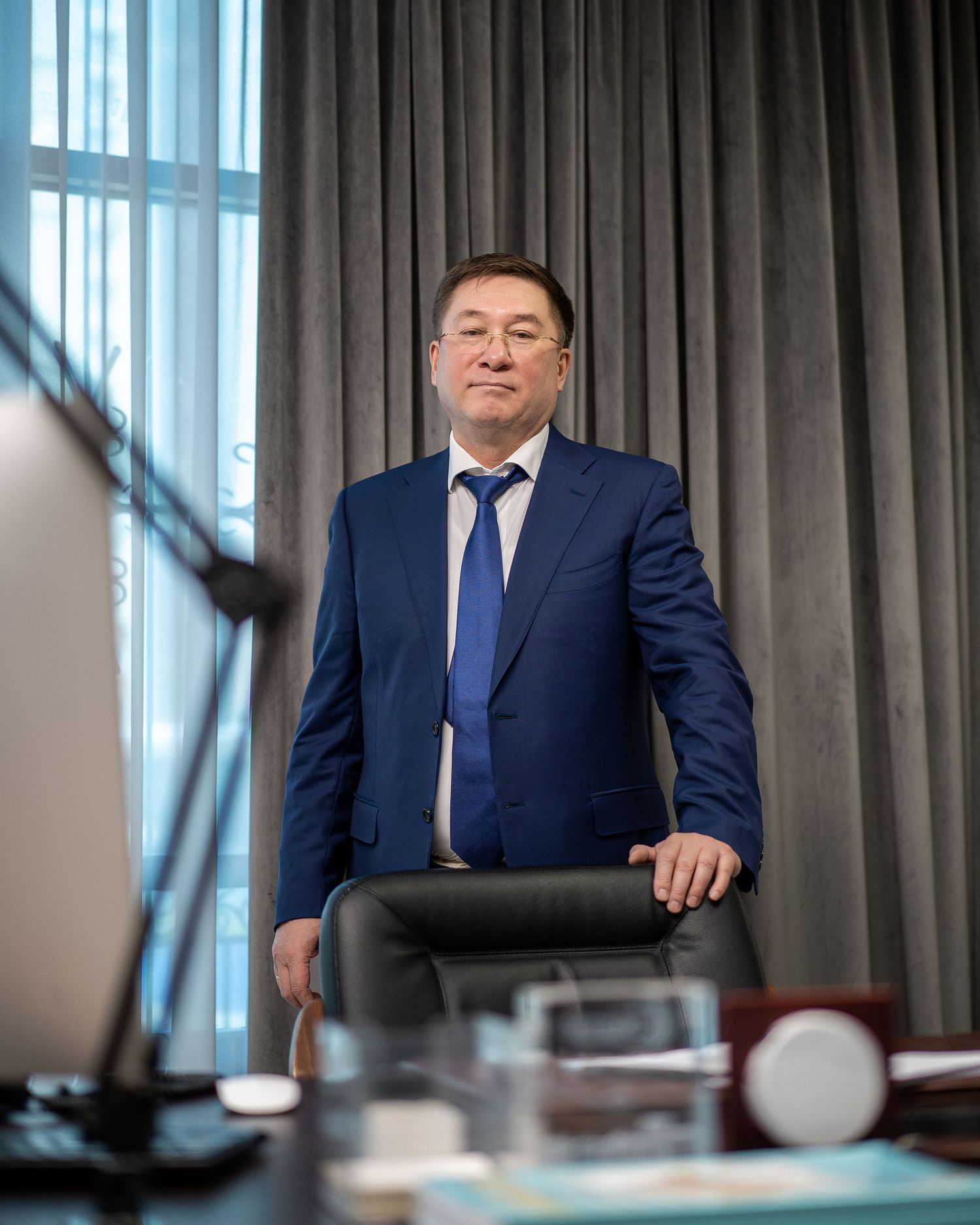 Corporate portrait series showing executive in blue suit at conference table.
