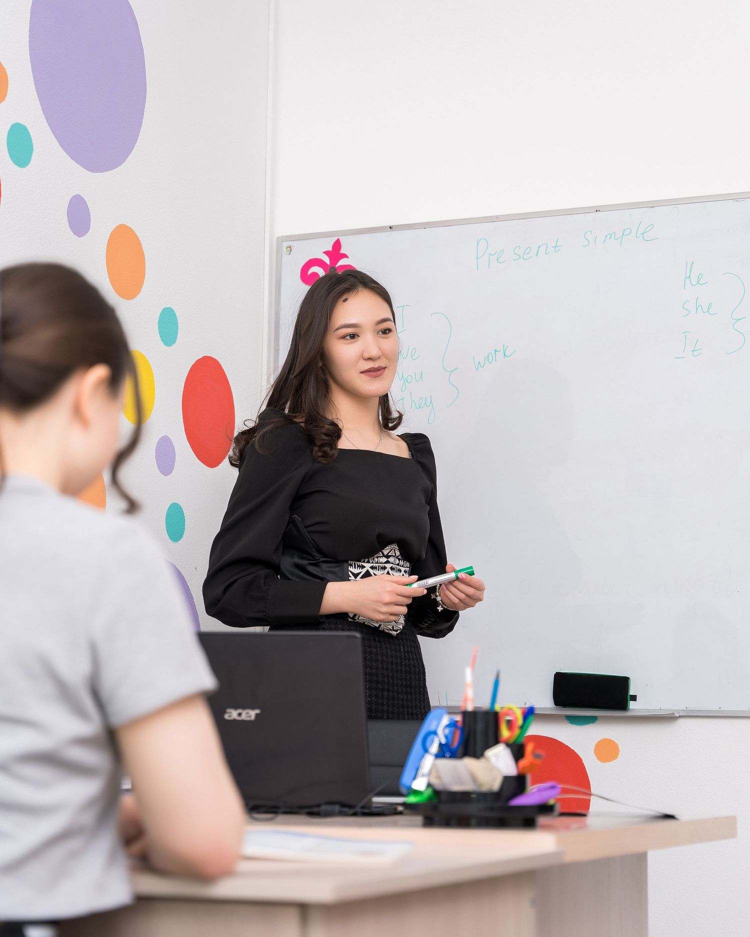 Professional workspace with laptop and colorful polka dot wall decor in modern office setting.