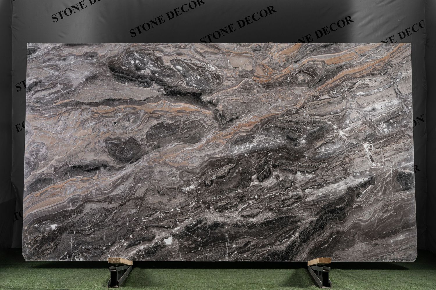 Natural stone slabs with dramatic gray and brown marbling patterns displayed in showroom.