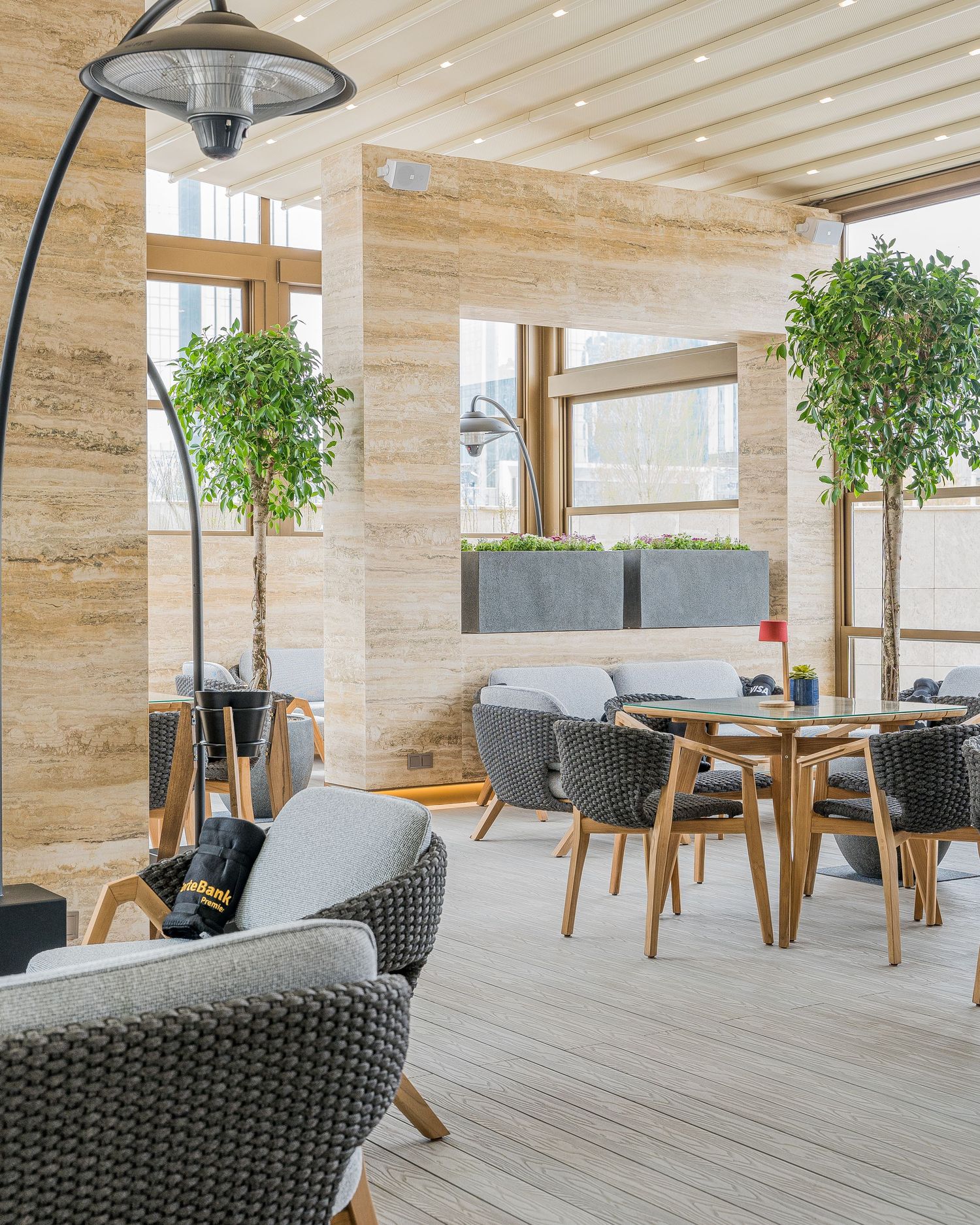 Spacious dining terrace with rattan chairs, wooden tables, and natural stone walls.