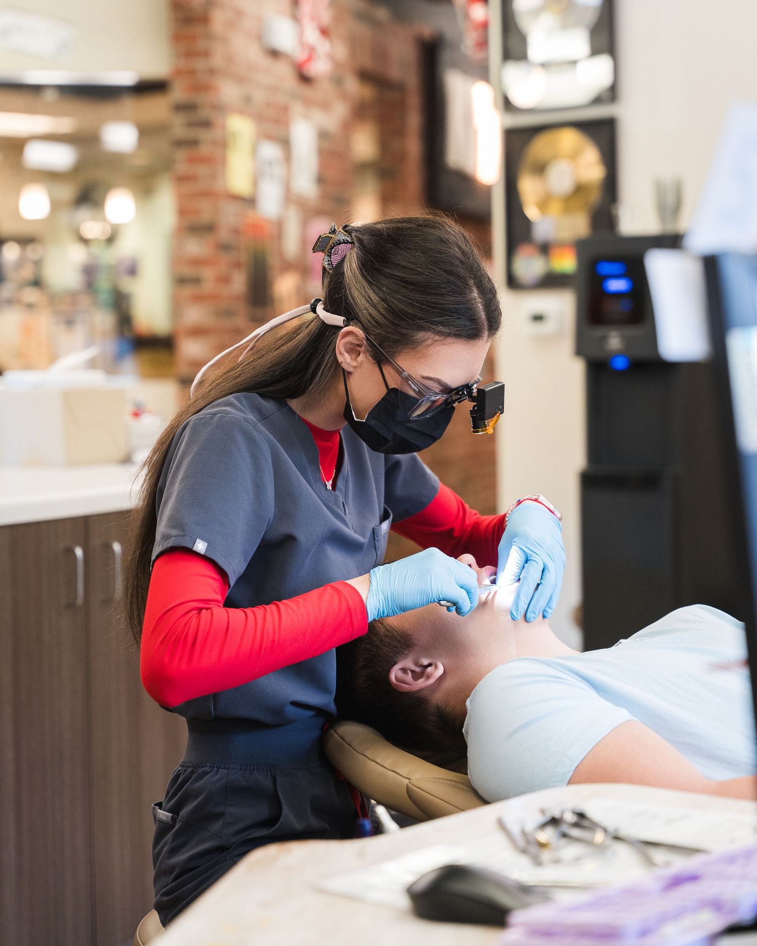 Dental professionals performing treatment procedures in a modern clinic setting.