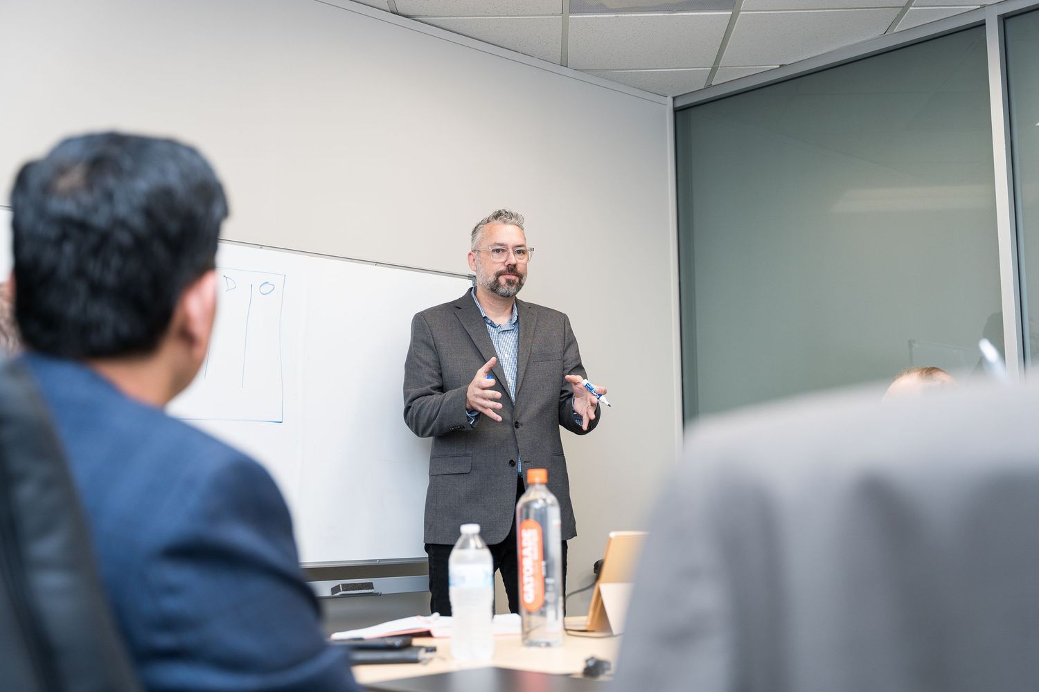Professional speaker presenting at a business meeting in modern conference room.