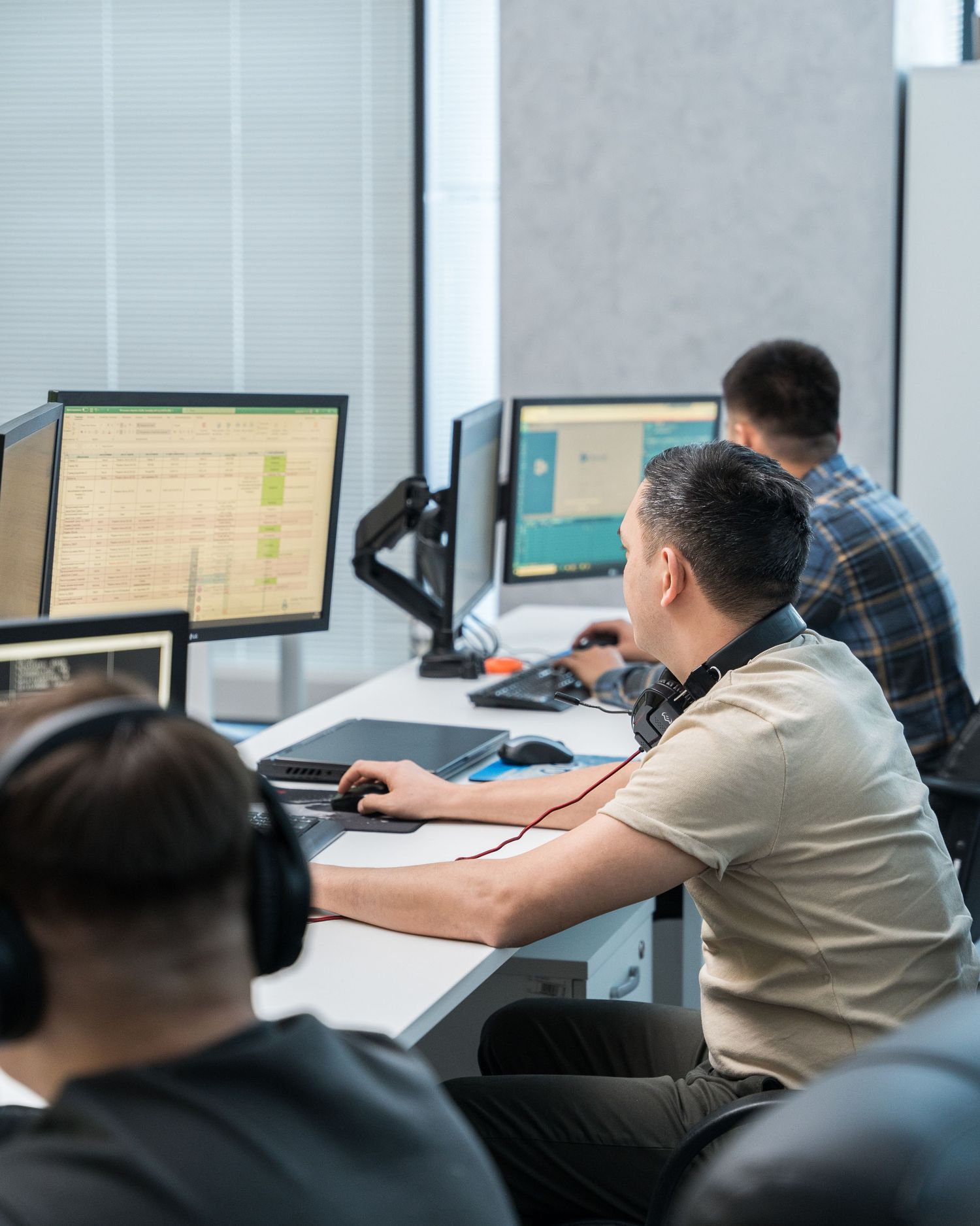 Multiple employees working at computer stations in an open office environment.