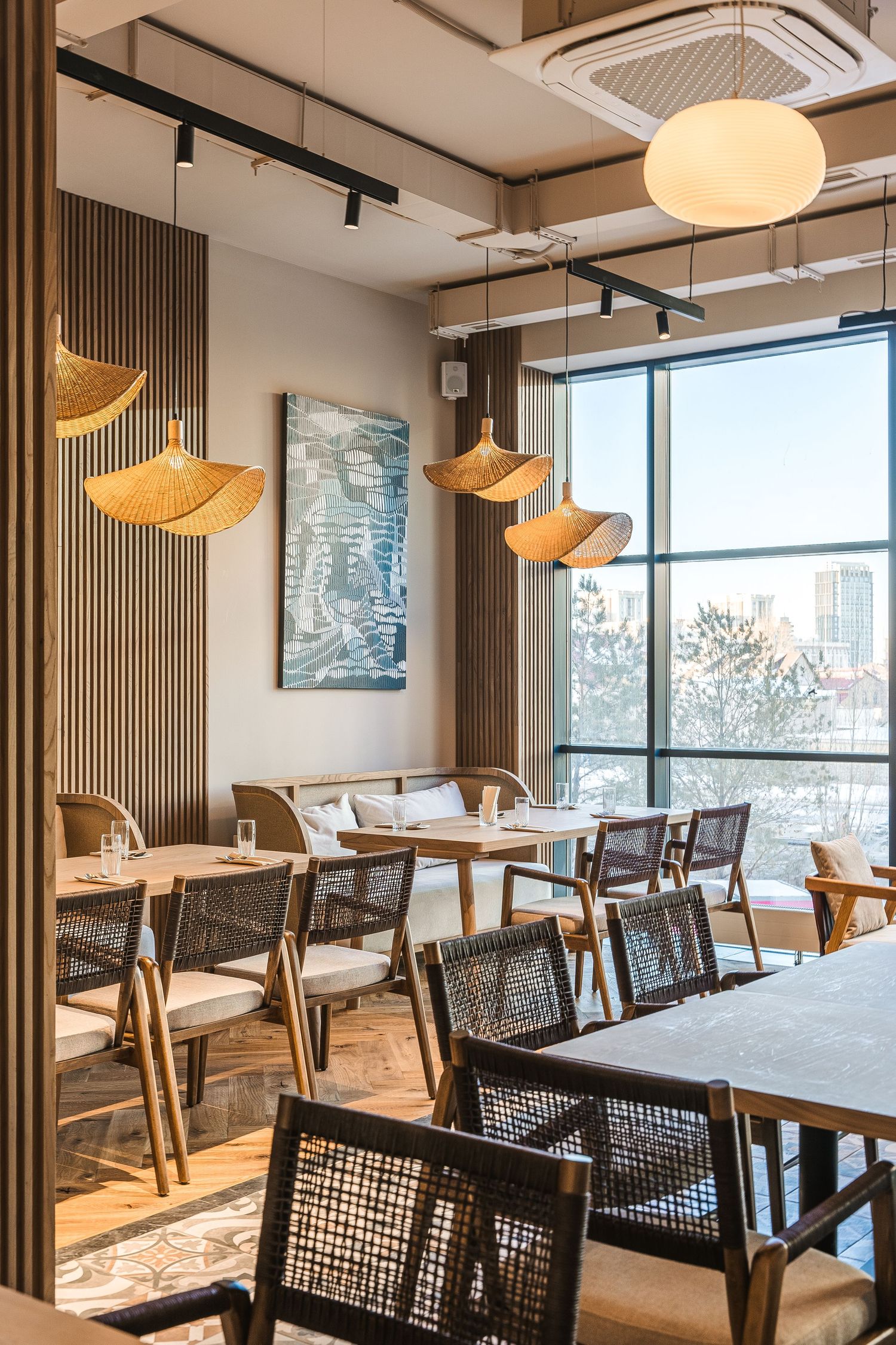 Bright dining area with large windows, wooden accents, and contemporary pendant lighting.