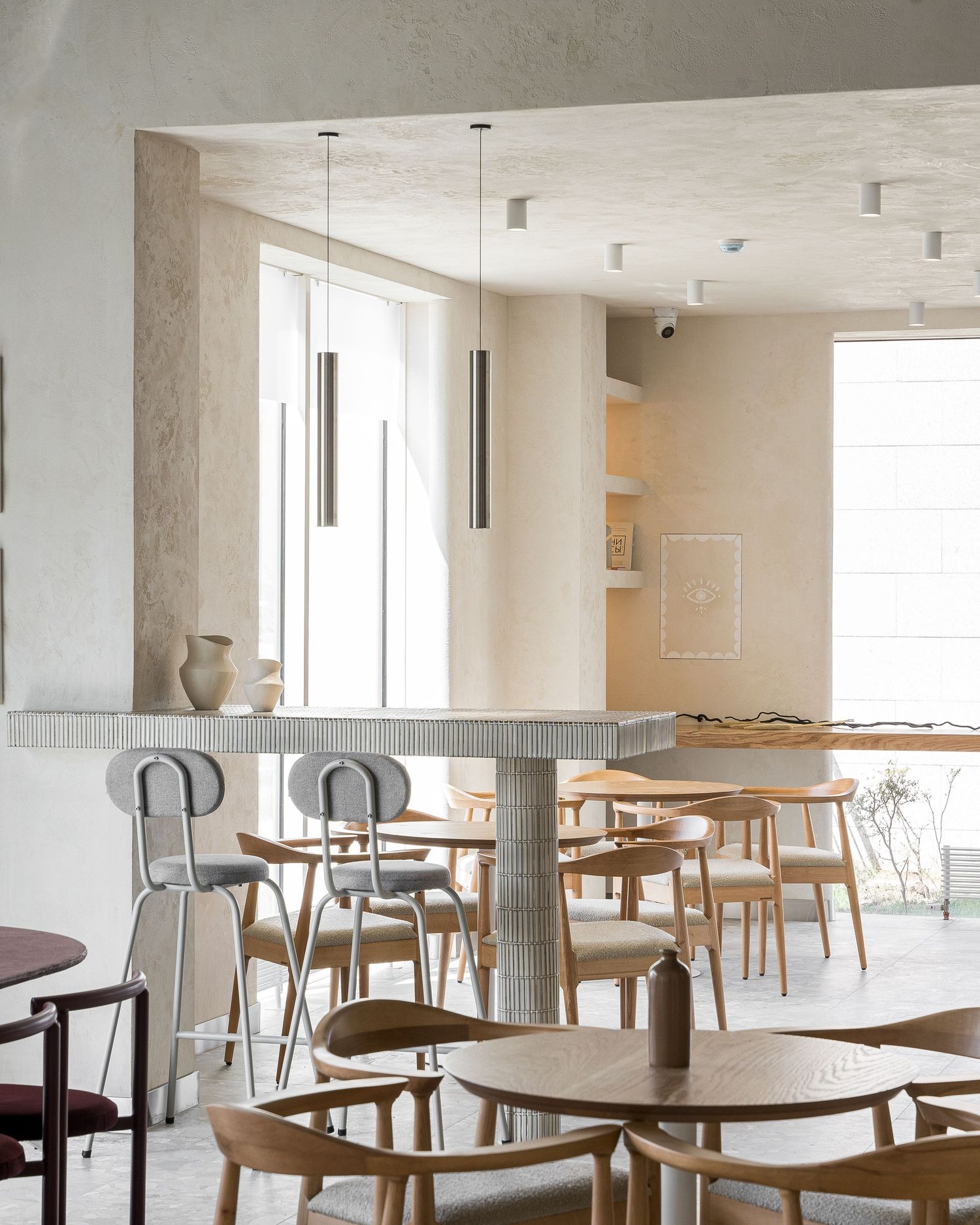 Bright restaurant interior with wooden dining tables and chairs arranged in a spacious setting.