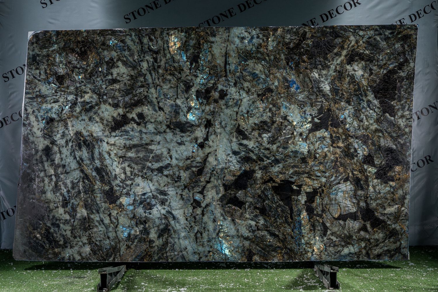Luxury marble slabs with blue-green and white veining patterns displayed against dark background.