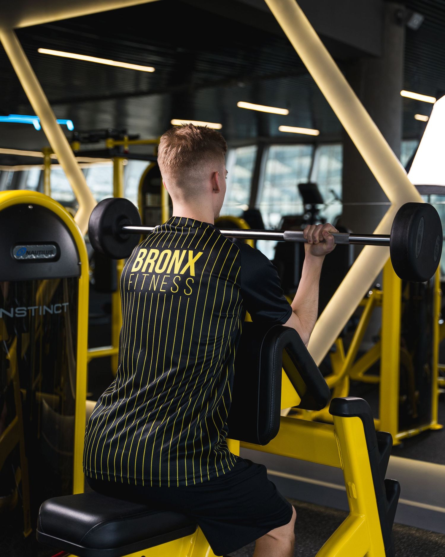 Athletes training in modern gym with yellow equipment and striped uniforms.