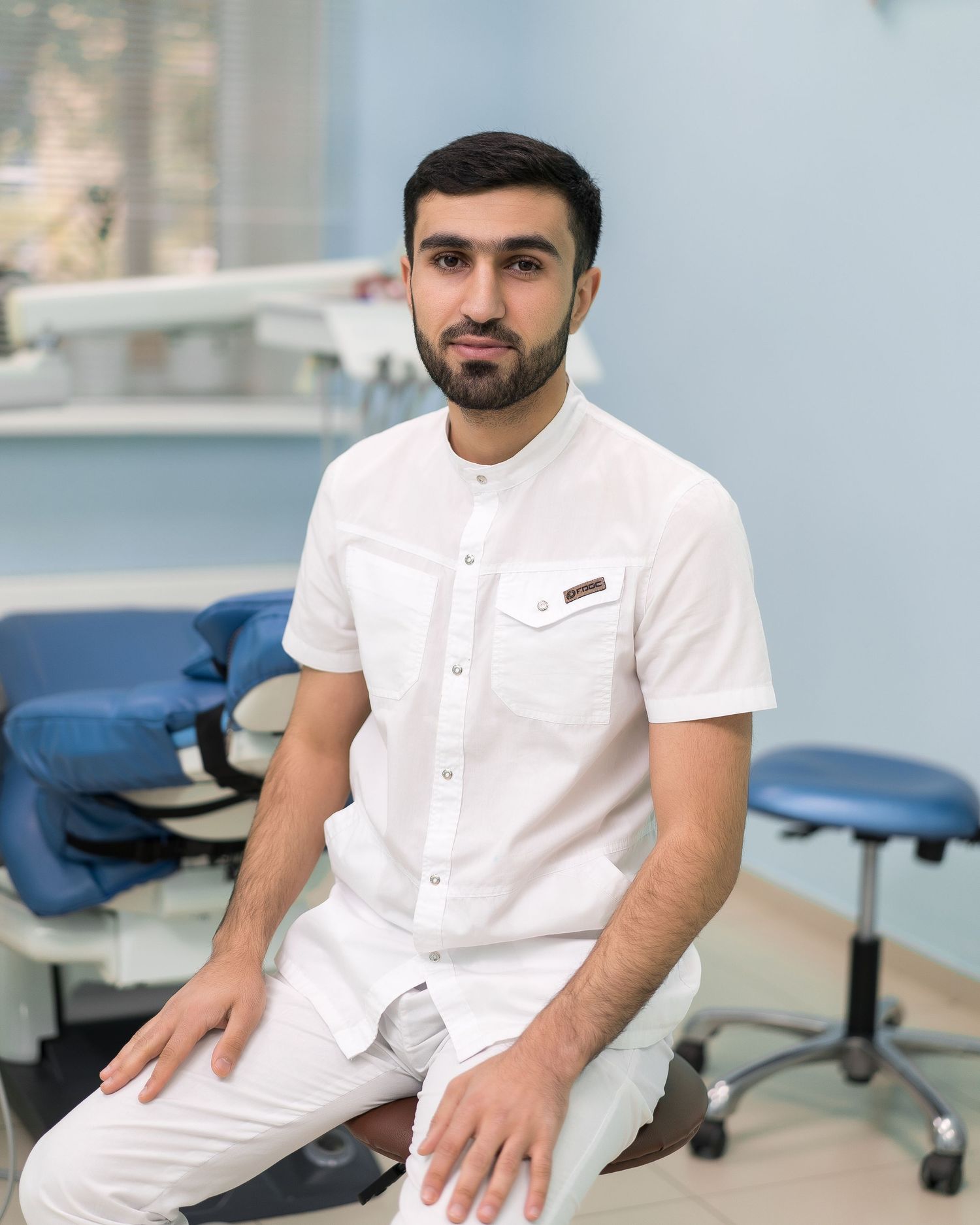 Healthcare professionals in white uniforms work in a modern medical facility with blue walls.