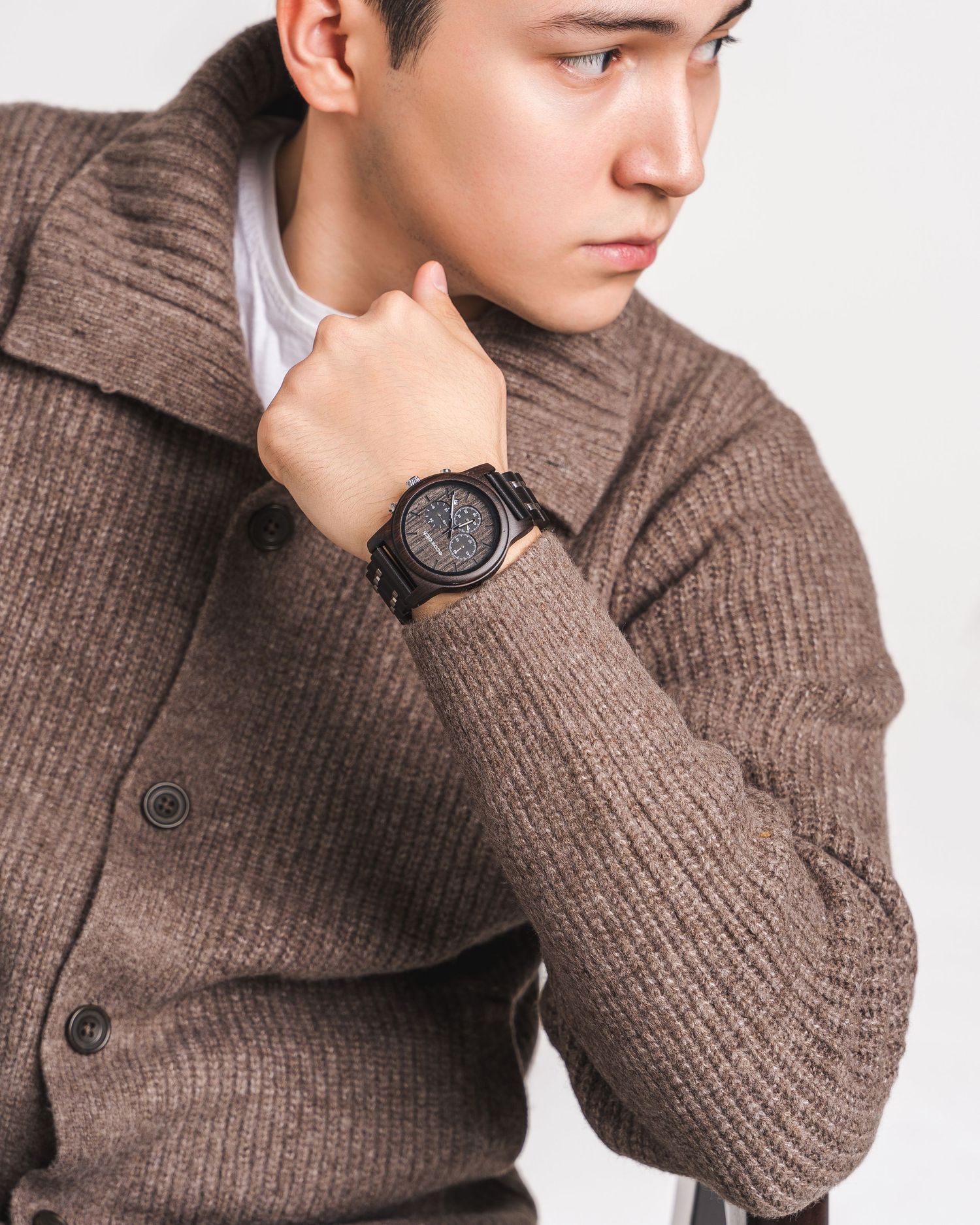 Person wearing brown knit sweater showing wrist watch from different angles.