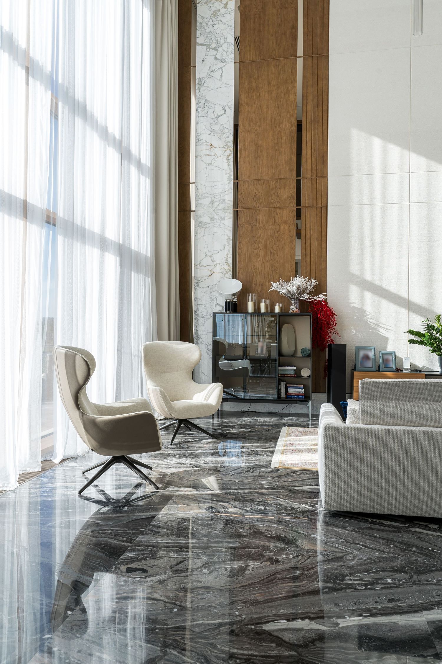 Luxurious living area with grey marble floors and modern white seating arrangements.