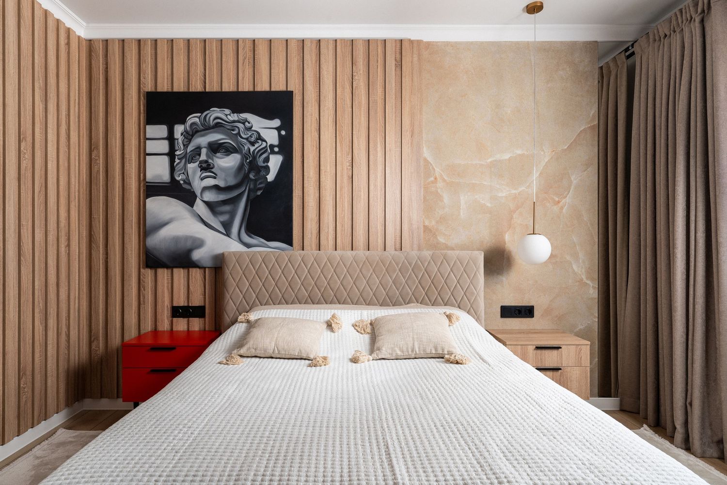 Minimalist bedroom with wooden slat wall panels and artistic black and white photography.
