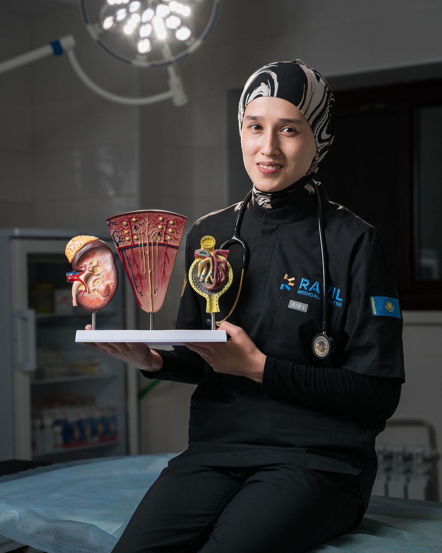 Medical professional in black uniform displaying educational anatomy models and charts.