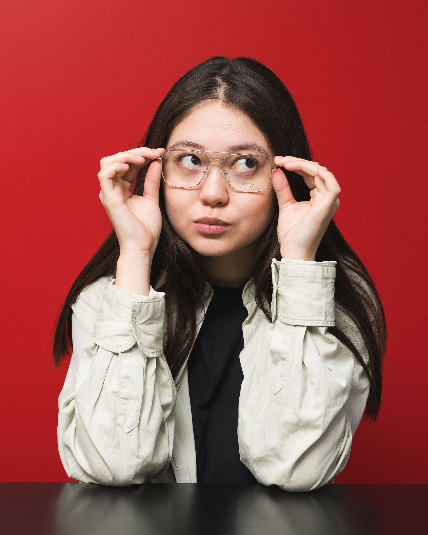 Fashion portrait series against red backdrop showing someone in white jacket and glasses.
