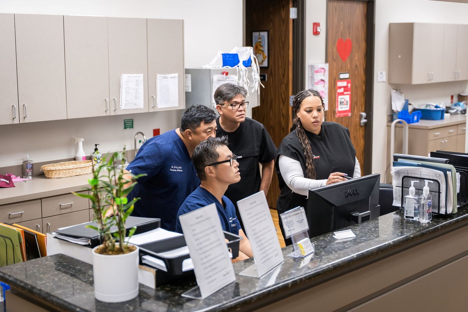 Medical staff working together at laboratory counter with equipment.