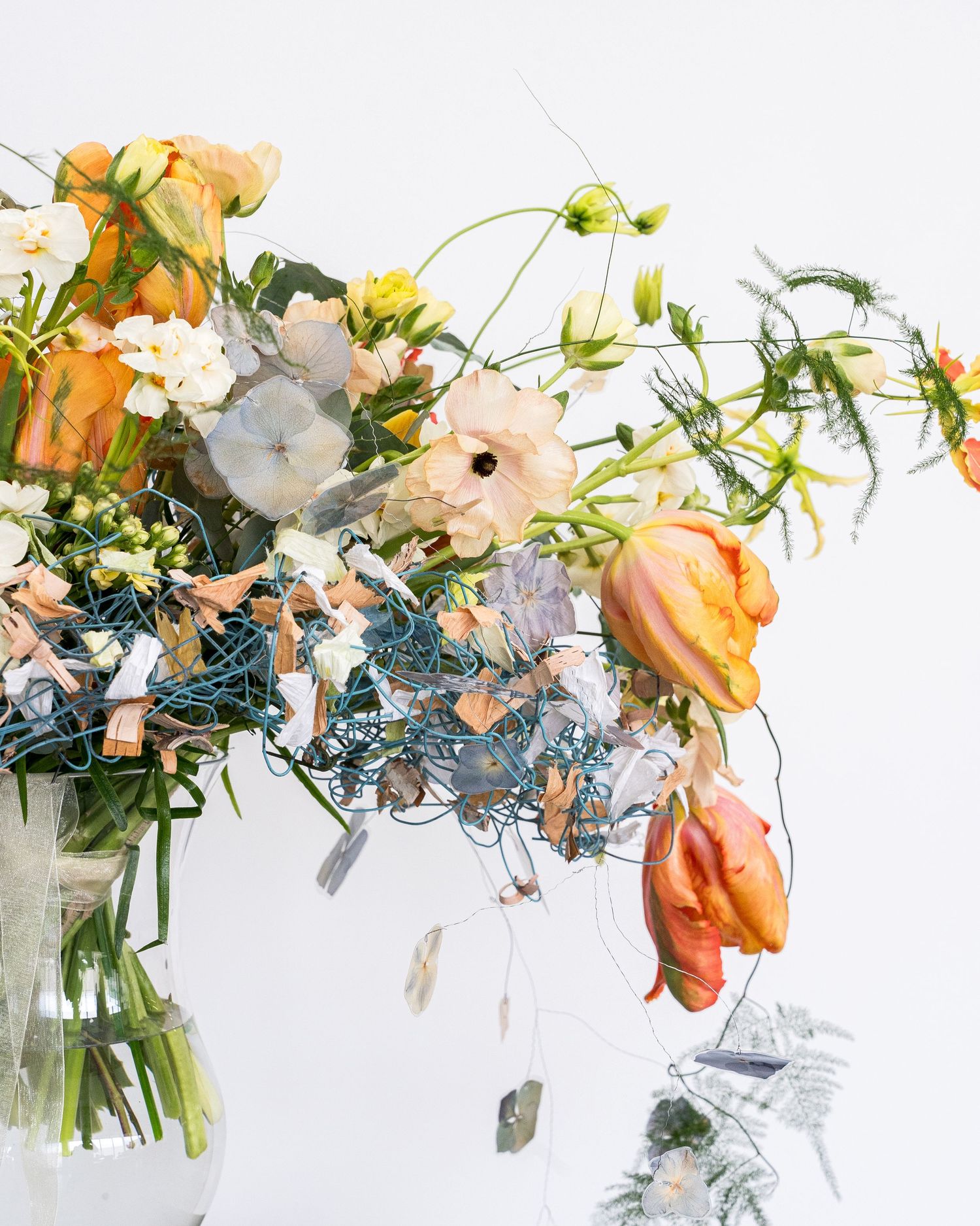 Artistic floral arrangement with peach and white flowers in modern vases.