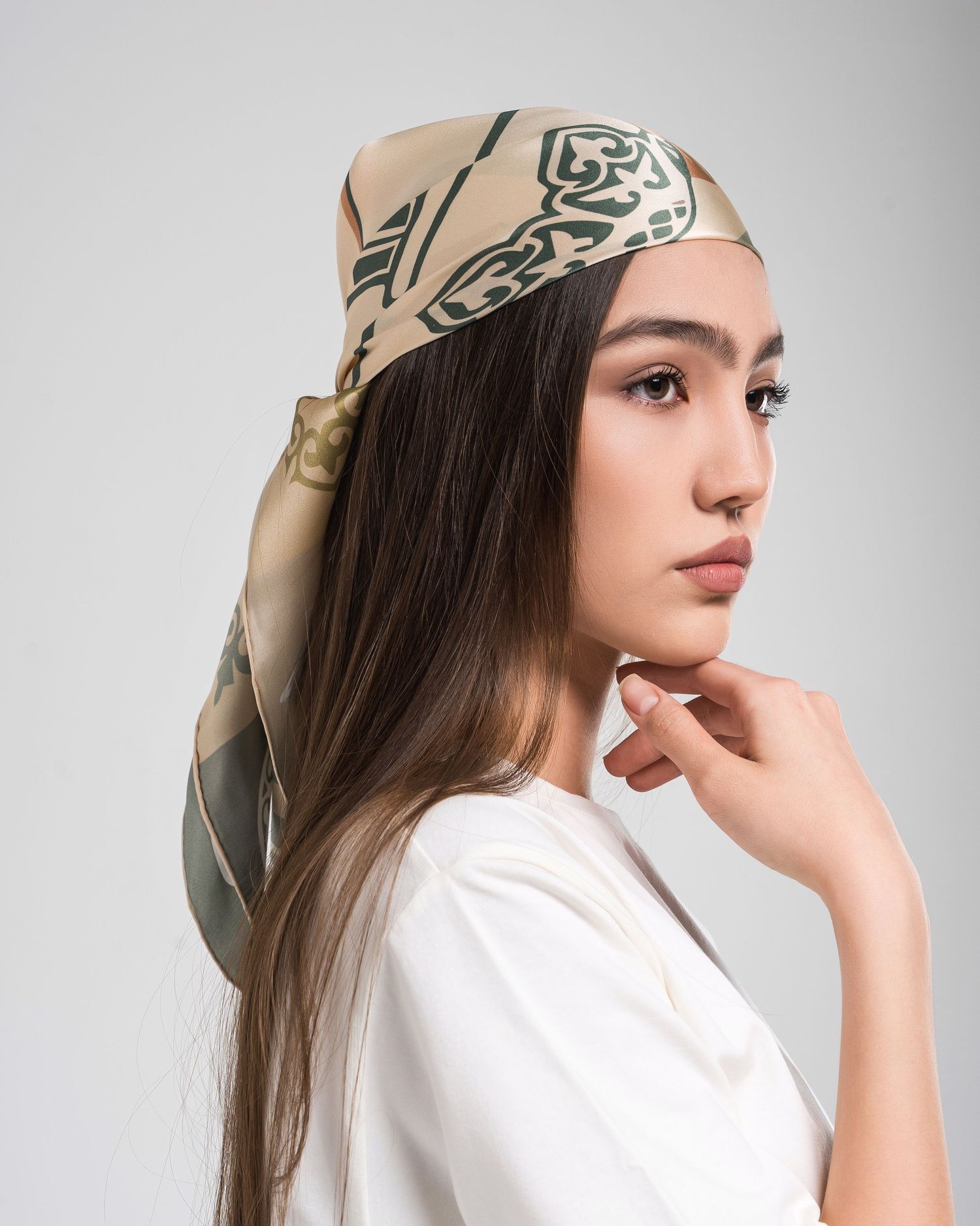 Fashion model wearing a beige patterned headscarf and white top in a series of artistic poses against white background.