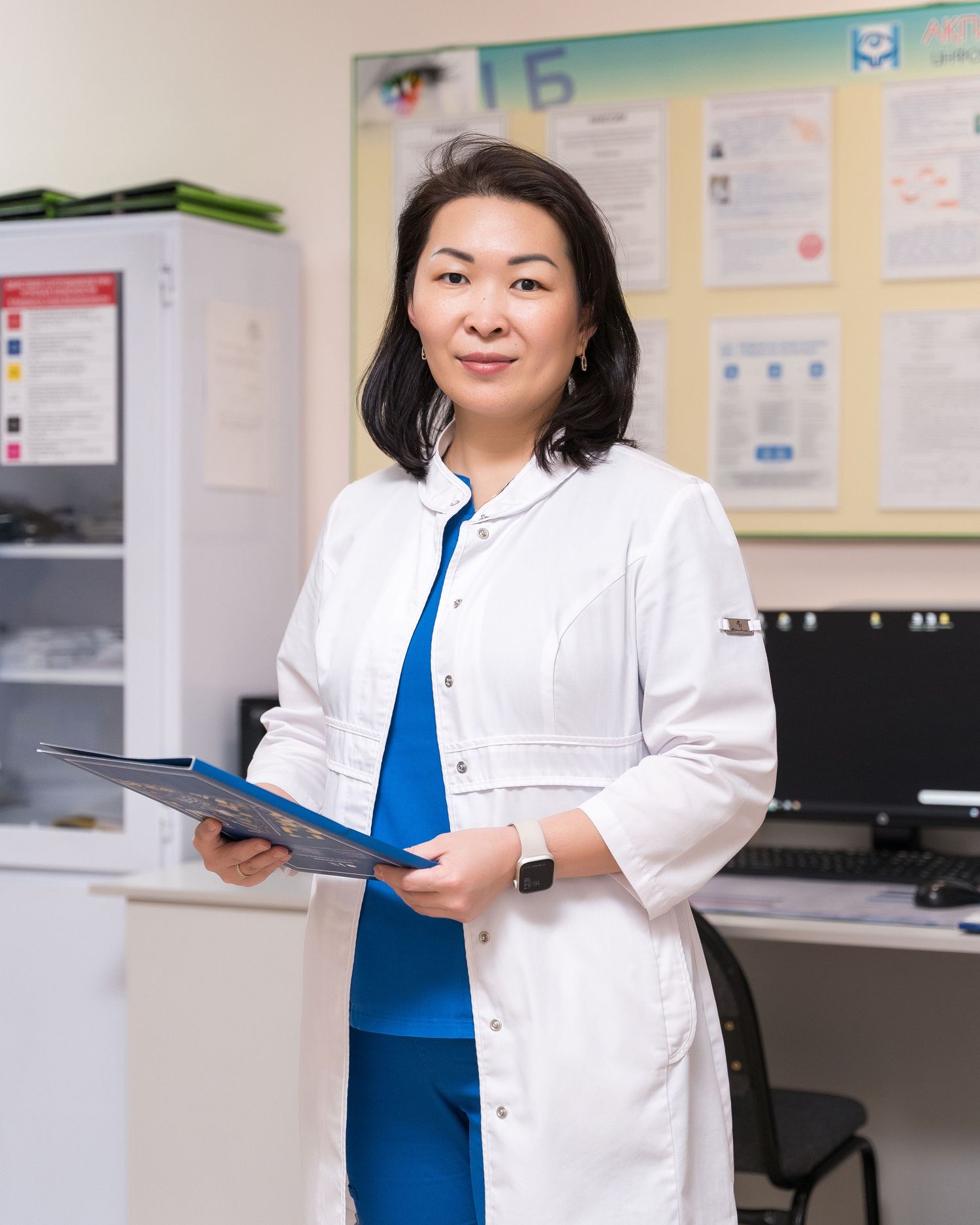 Healthcare professional in white lab coat holding clipboard in medical office.